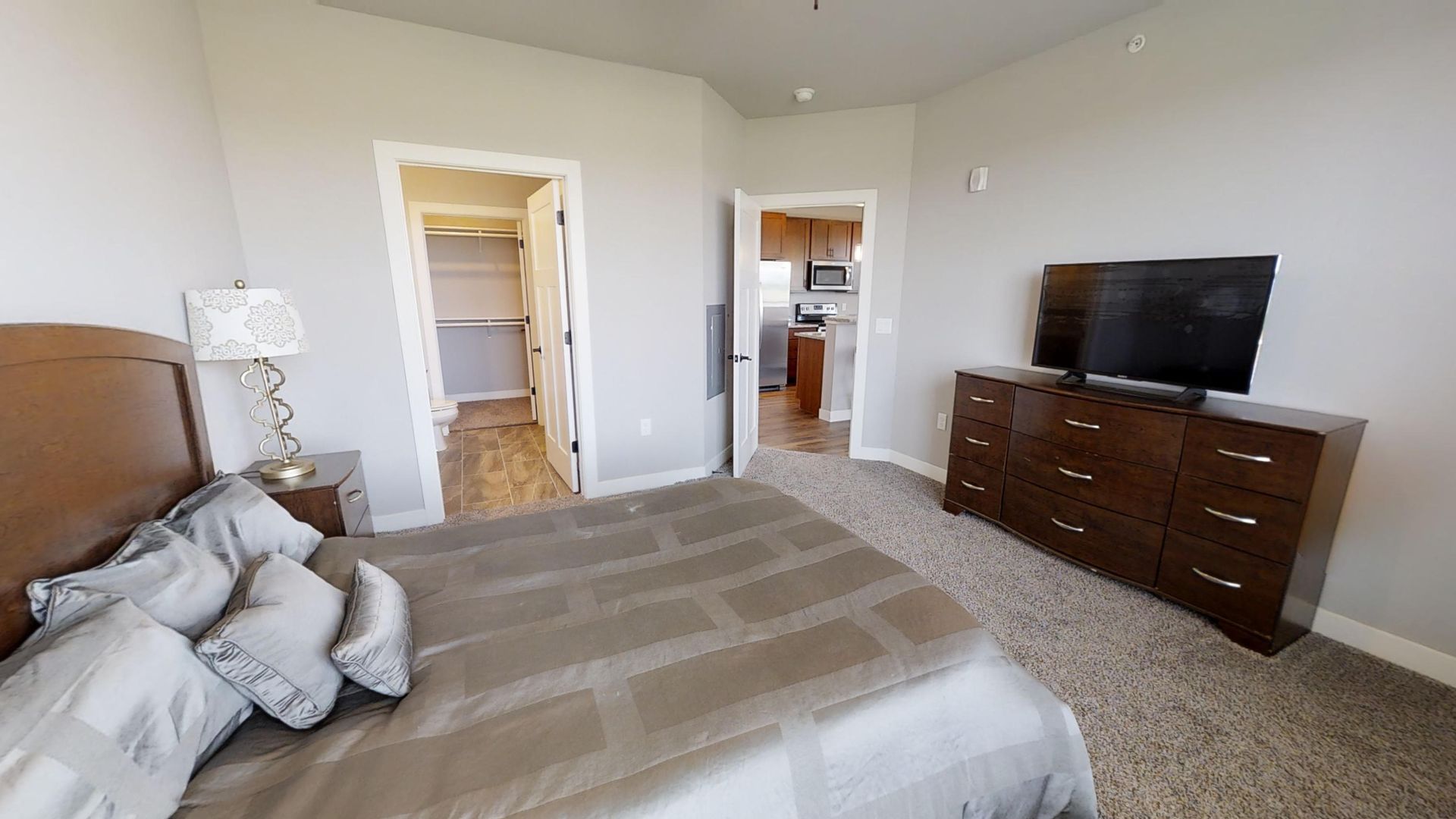 a bedroom with a large bed and a flat screen tv