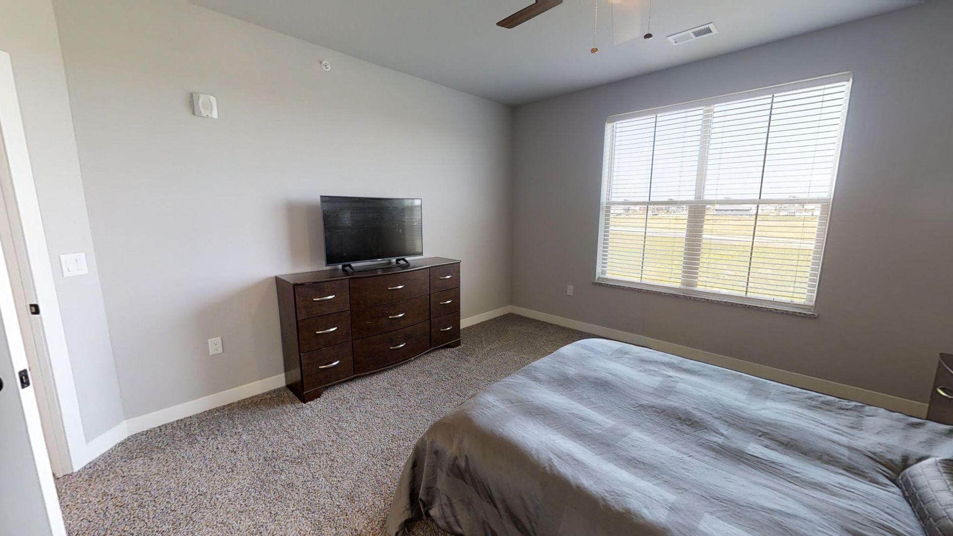 a bedroom with a dresser and a flat screen tv