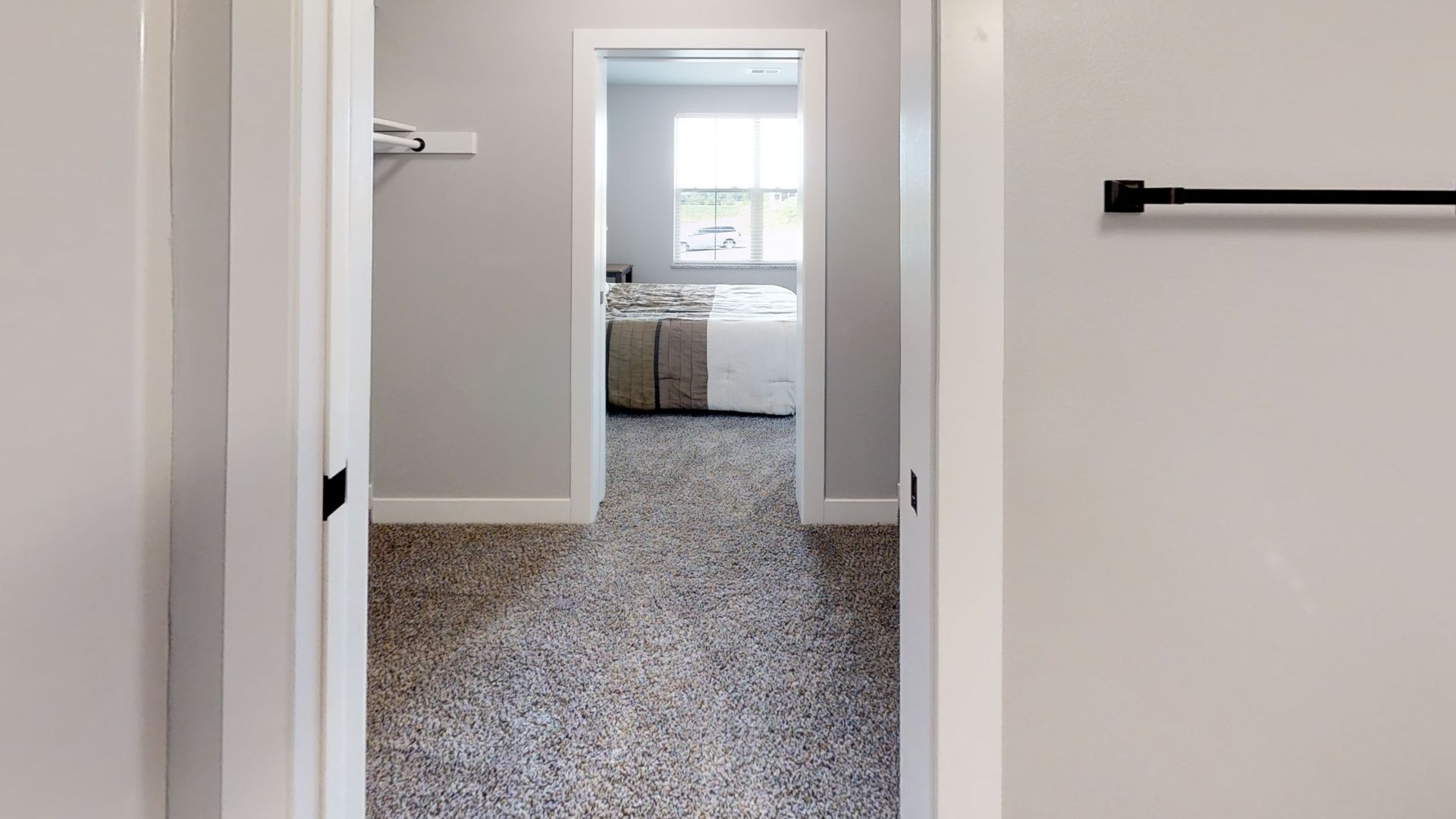 a walk in closet leading to a bedroom with a bed