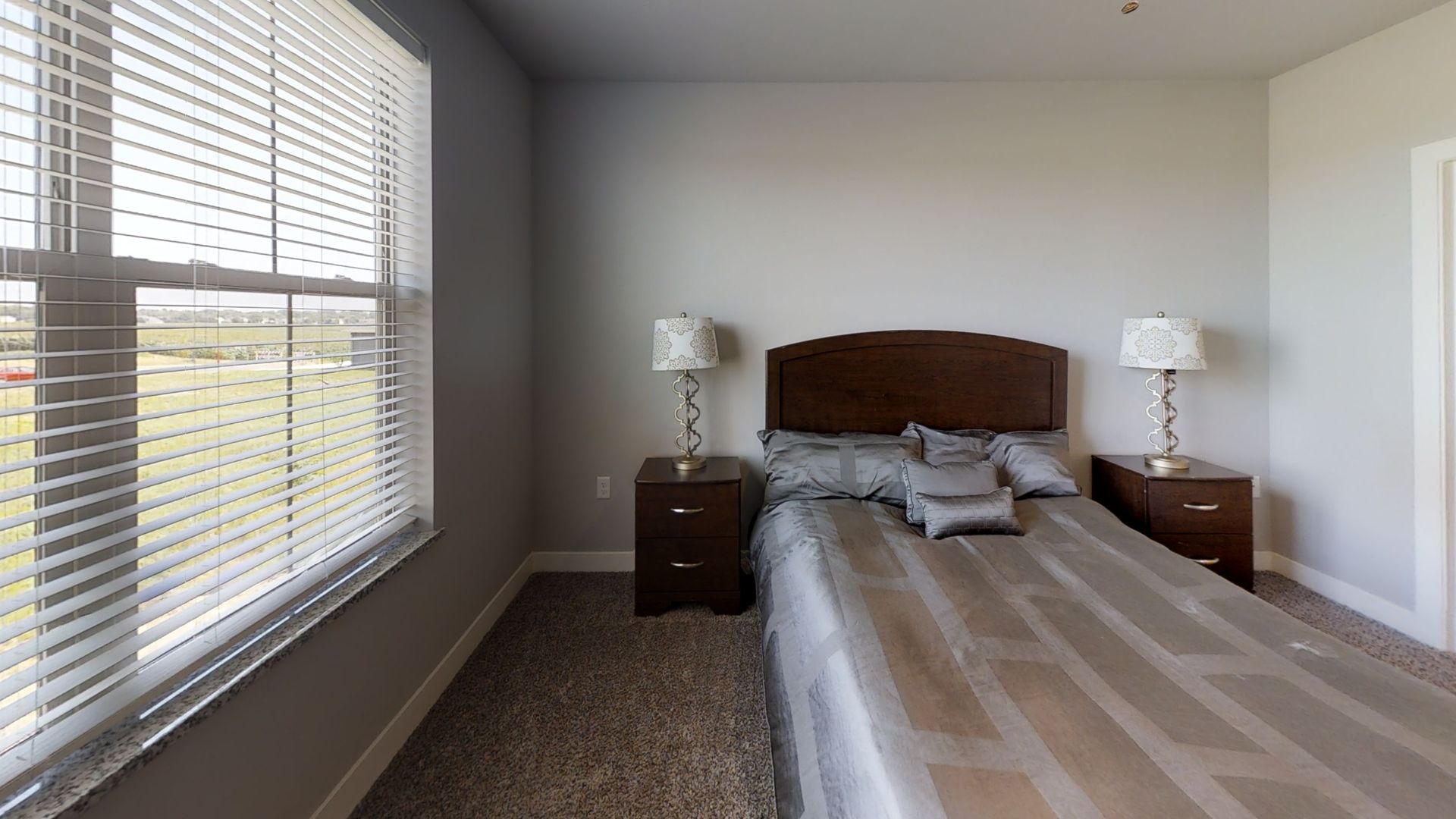 a bedroom with a bed two nightstands and a window
