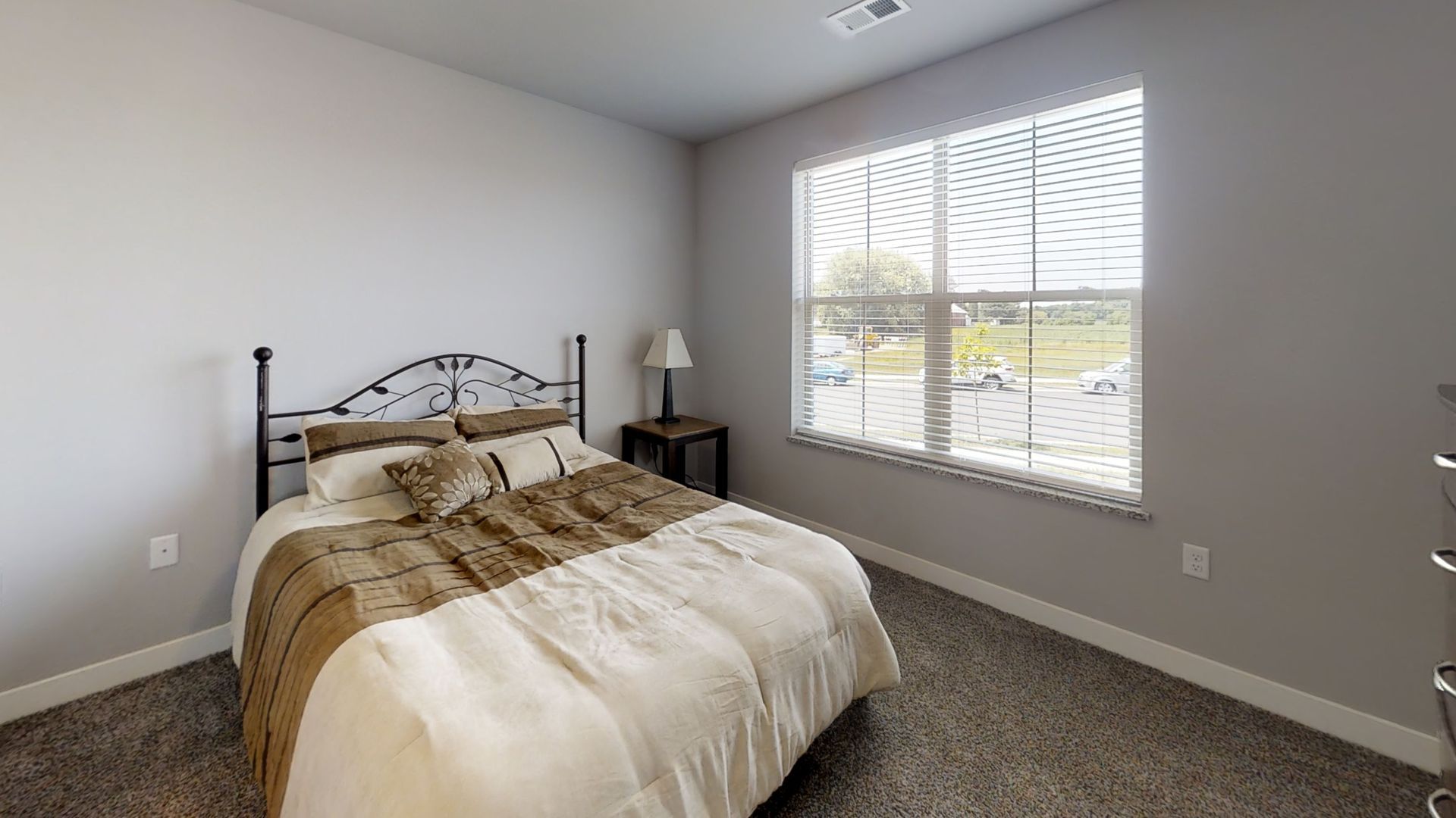 a bedroom with a bed and a window with blinds