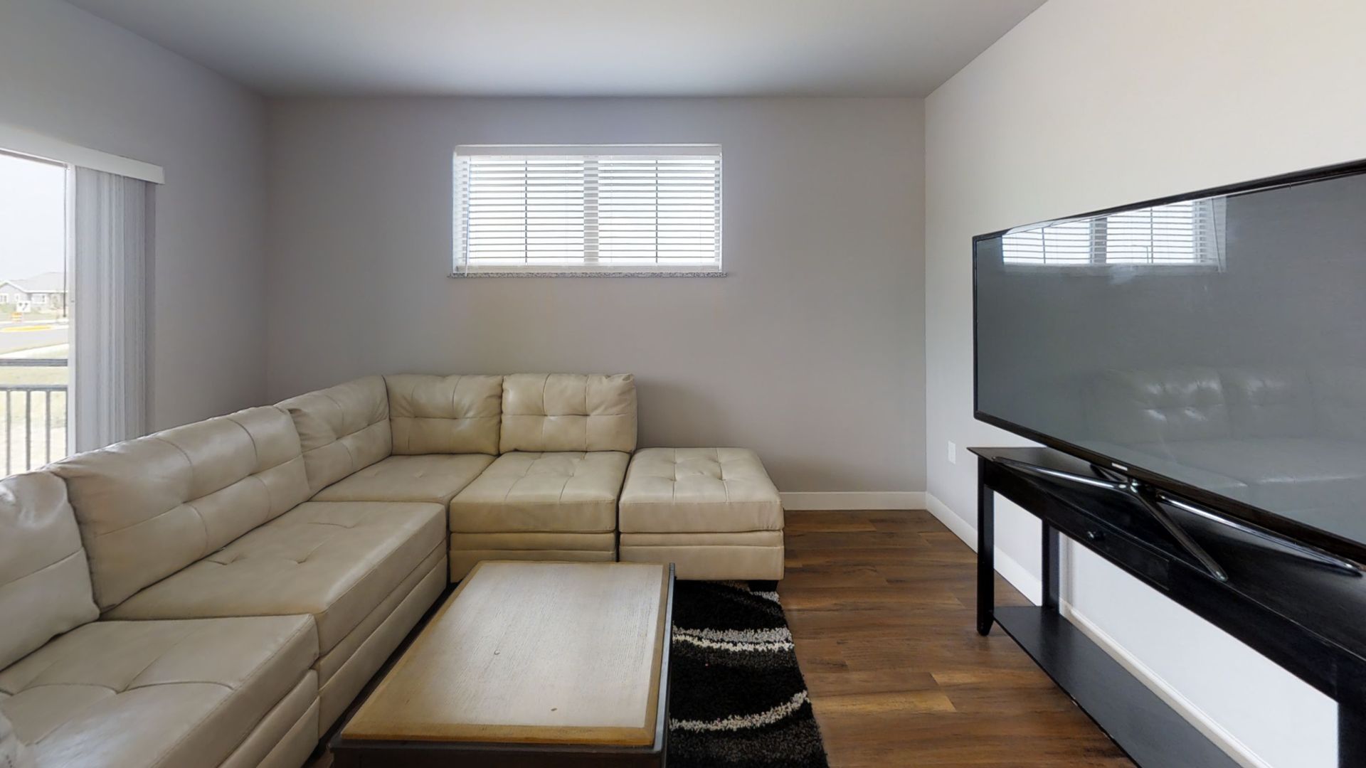a living room with a sectional couch and a flat screen tv