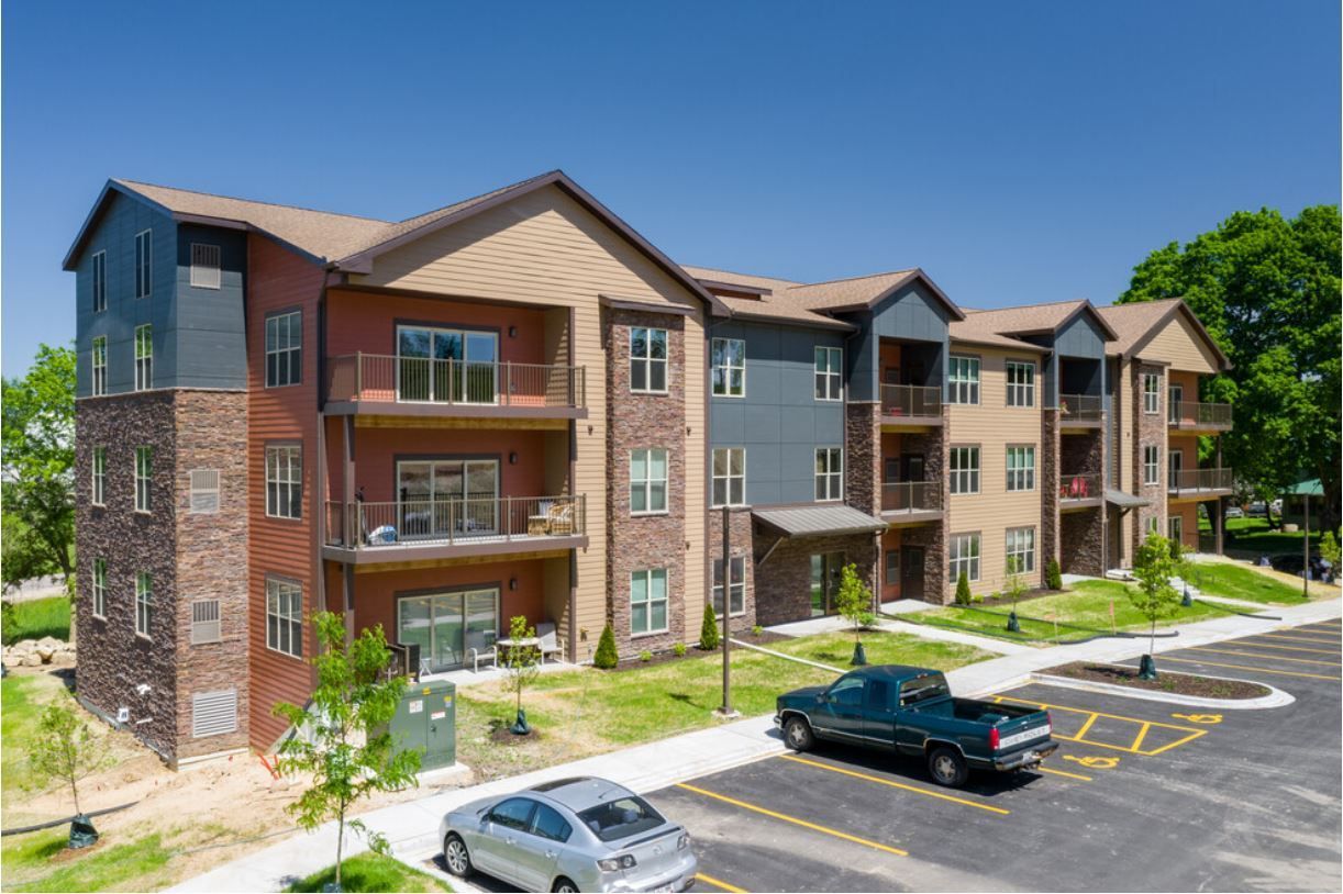 a large apartment building with cars parked in front of it