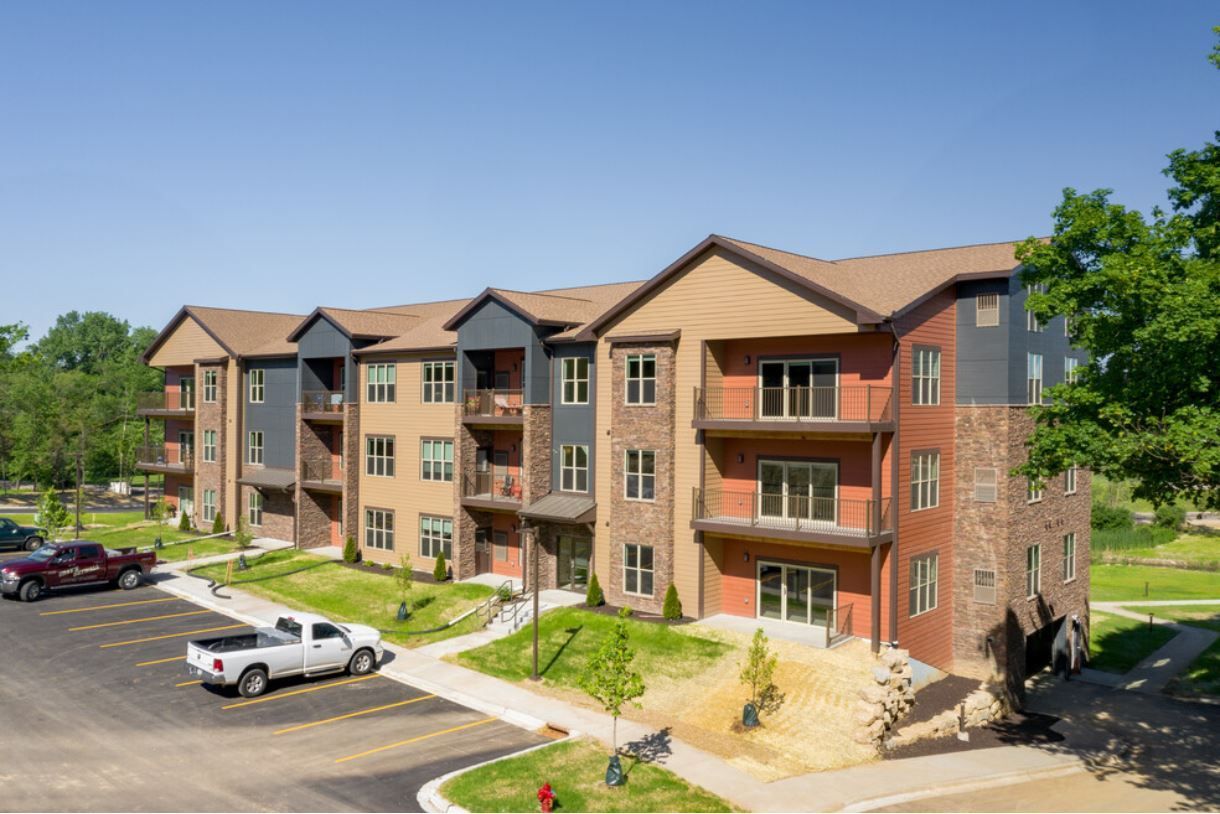 a large apartment building with cars parked in front of it