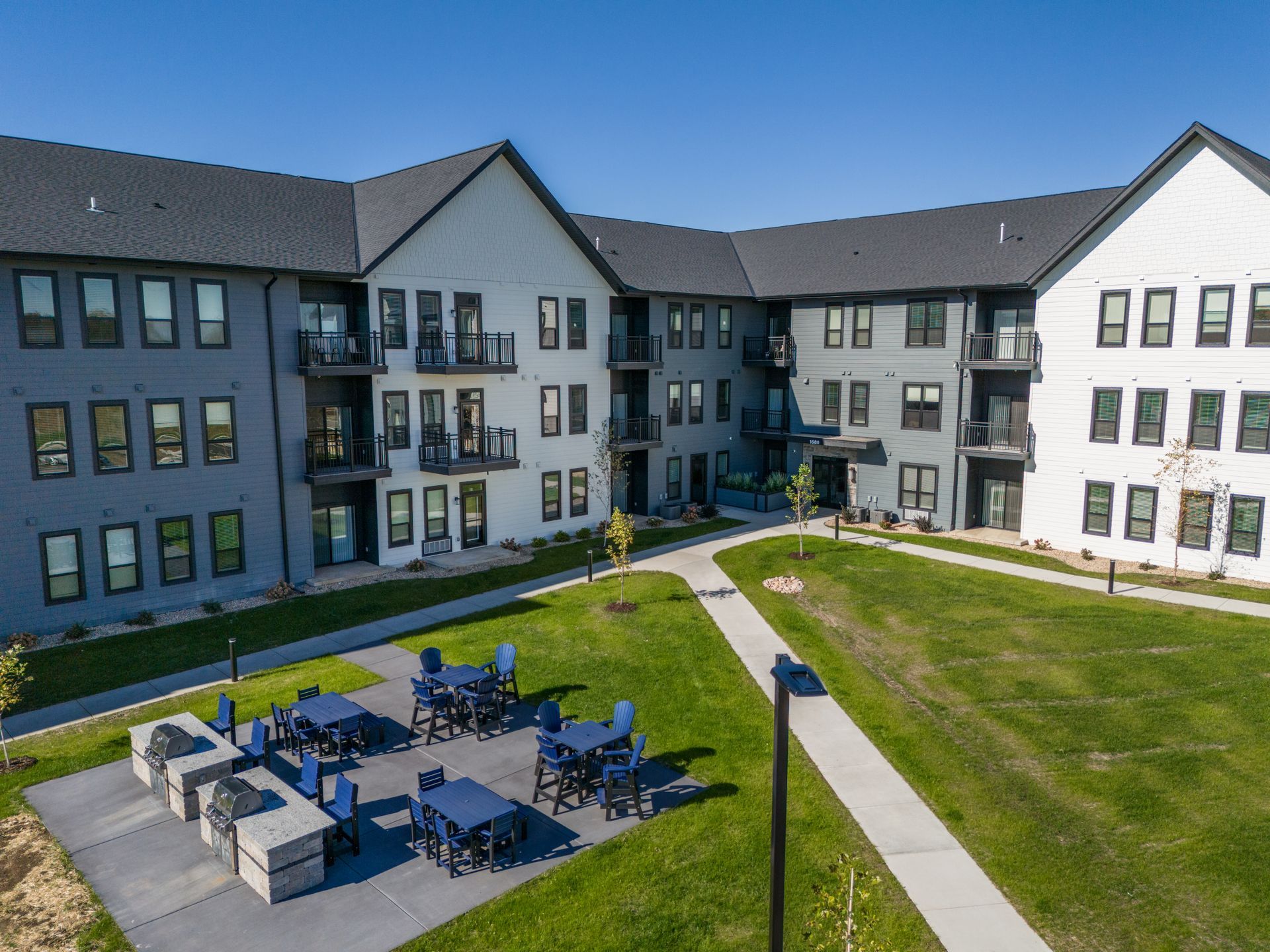 a large apartment building with tables and chairs in front of it