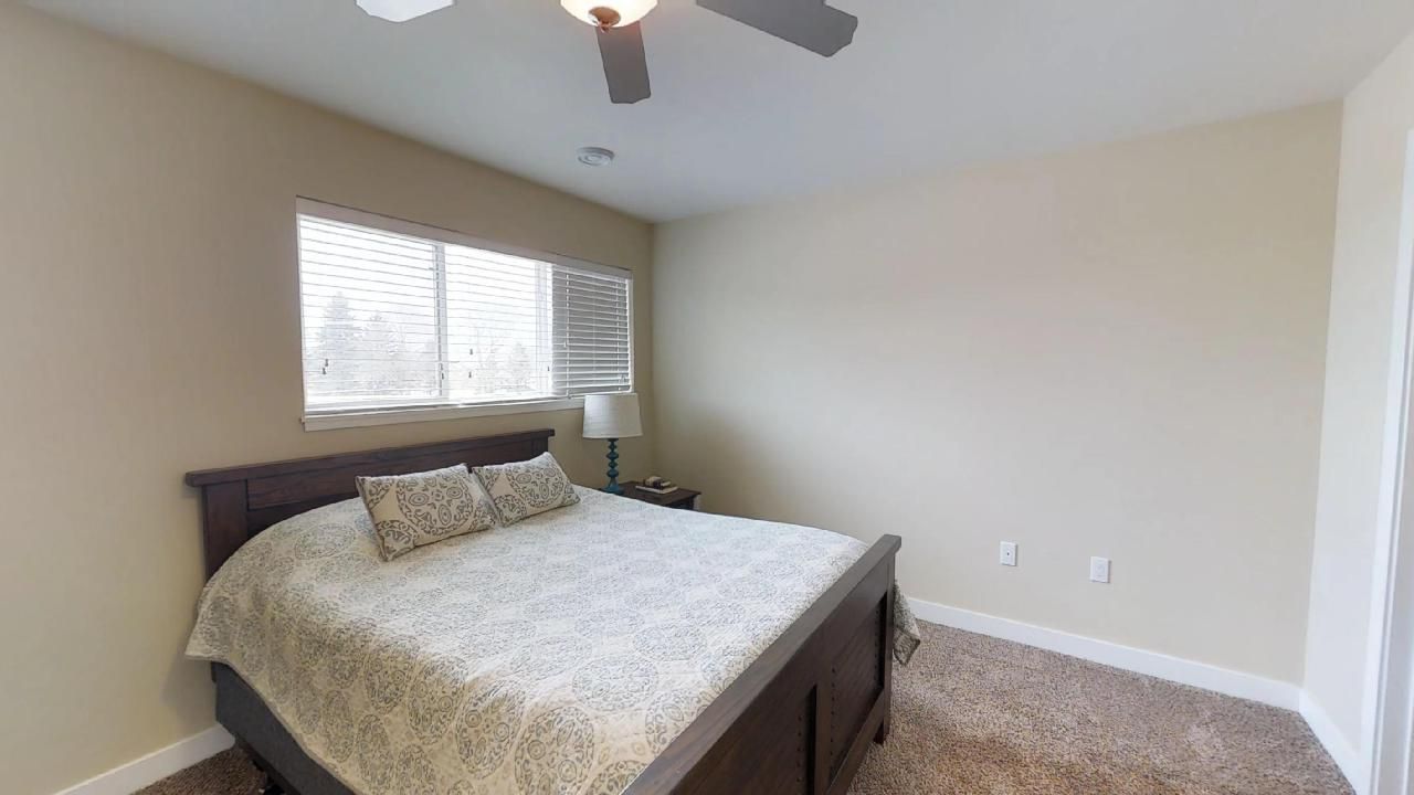 a bedroom with a bed and a ceiling fan