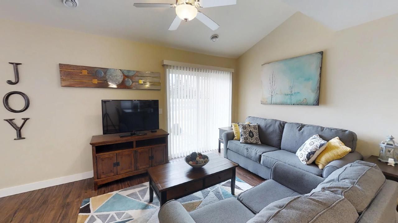 a living room with a couch a television and a sign that says joy
