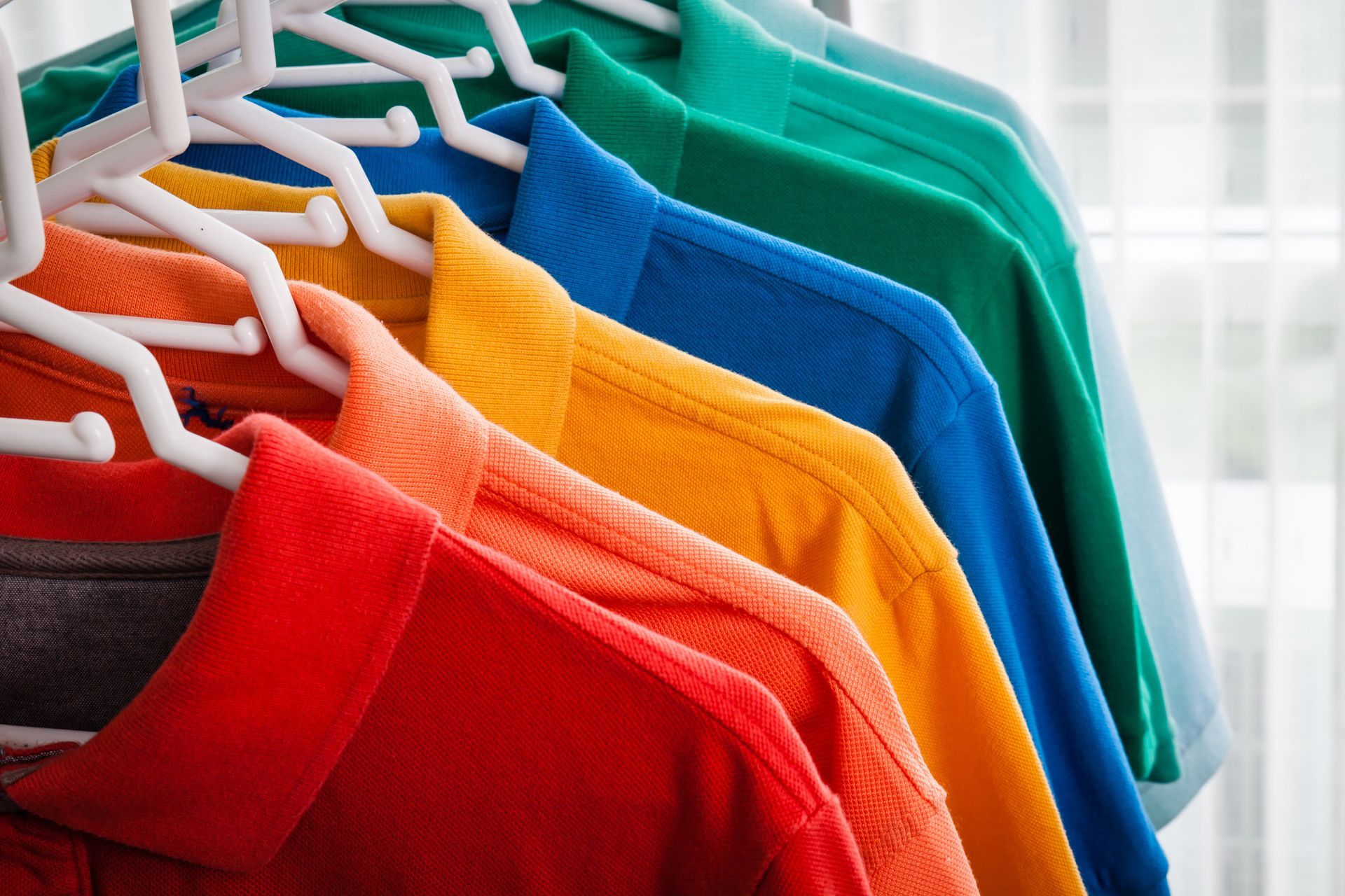 Gradient of colorful polo shirts on hangers Gradient of colorful polo shirts on hangers