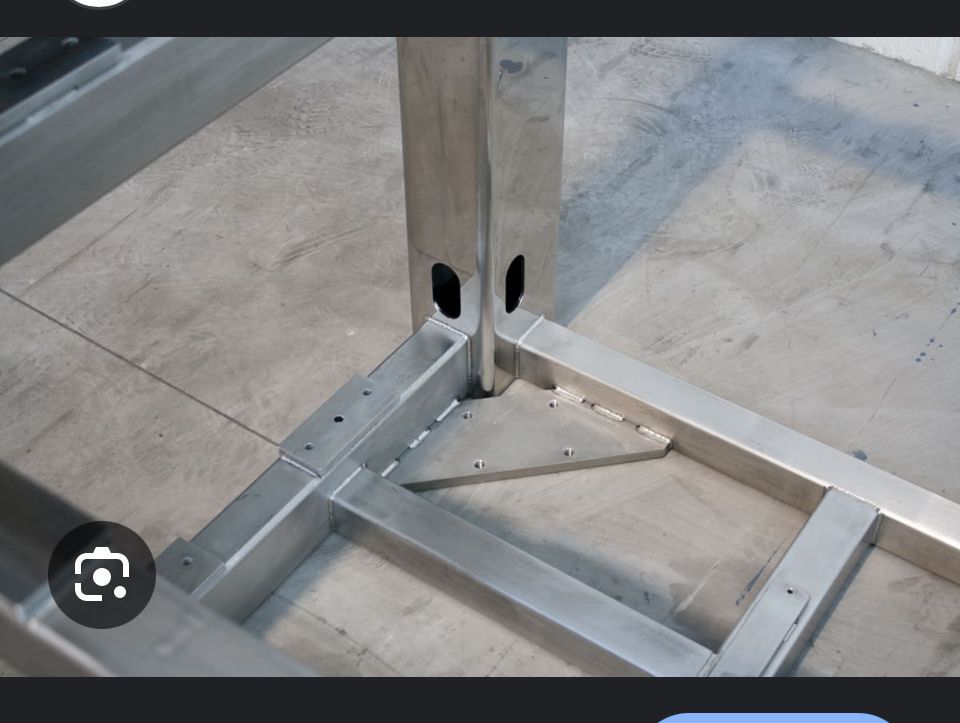 Struttura di base in metallo con tiranti diagonali imbullonati a un palo verticale in acciaio su un pavimento in cemento.