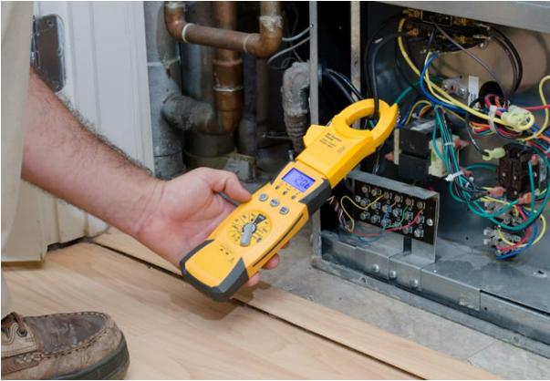 A man is holding a clamp meter in front of an air conditioner. A man is holding a clamp meter in front of an air conditioner.
