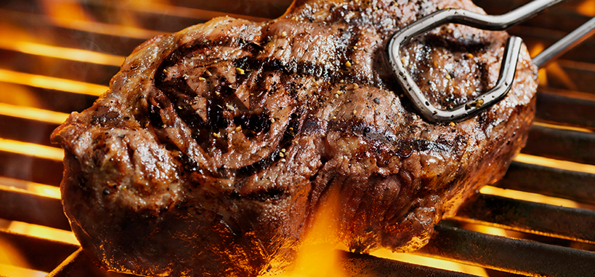steak on grill with Western Logo branded into the top