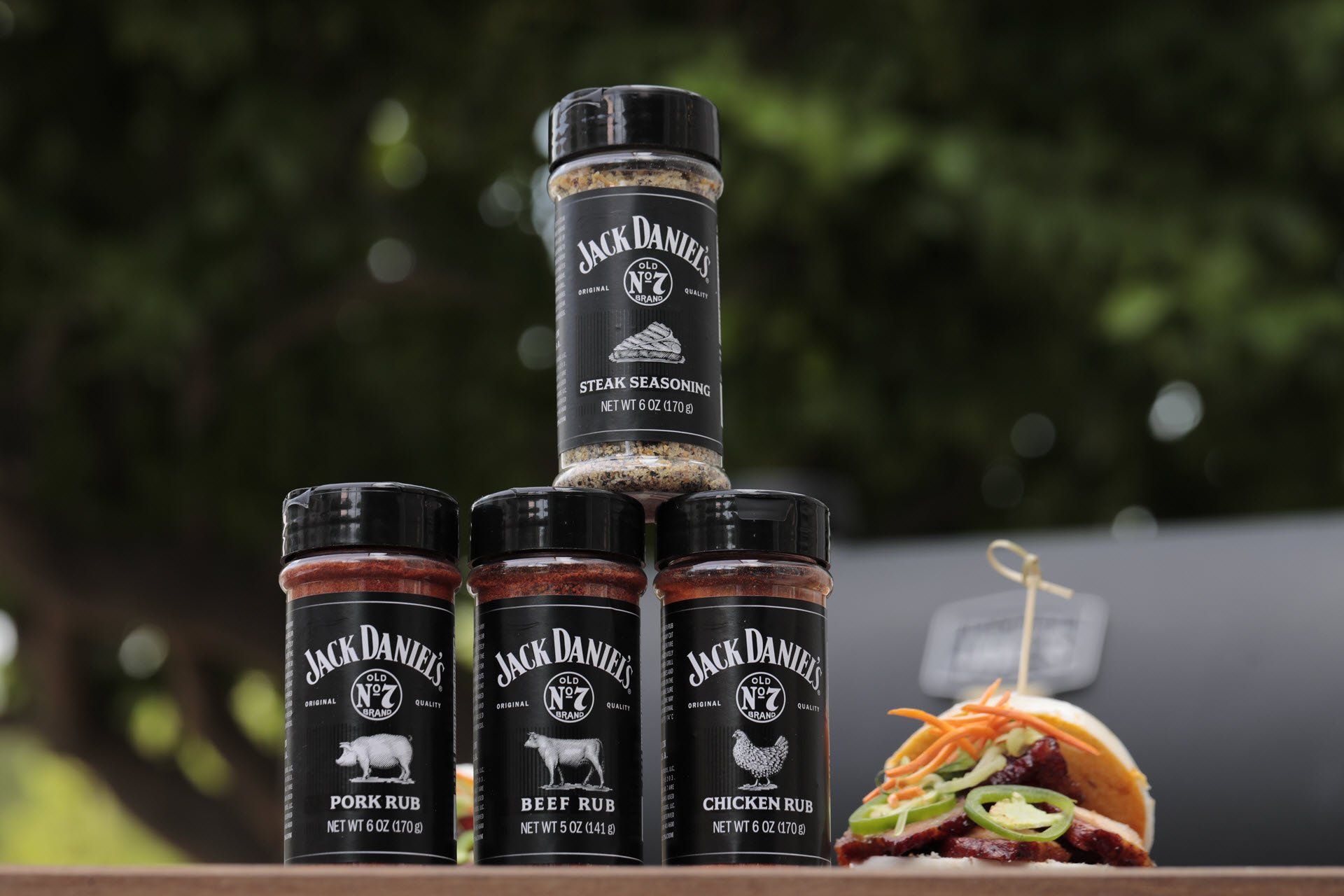 Jack Daniels Pork, Beef, Chicken Rubs & Steak Seasoning stacked with bbq pork sandwich
