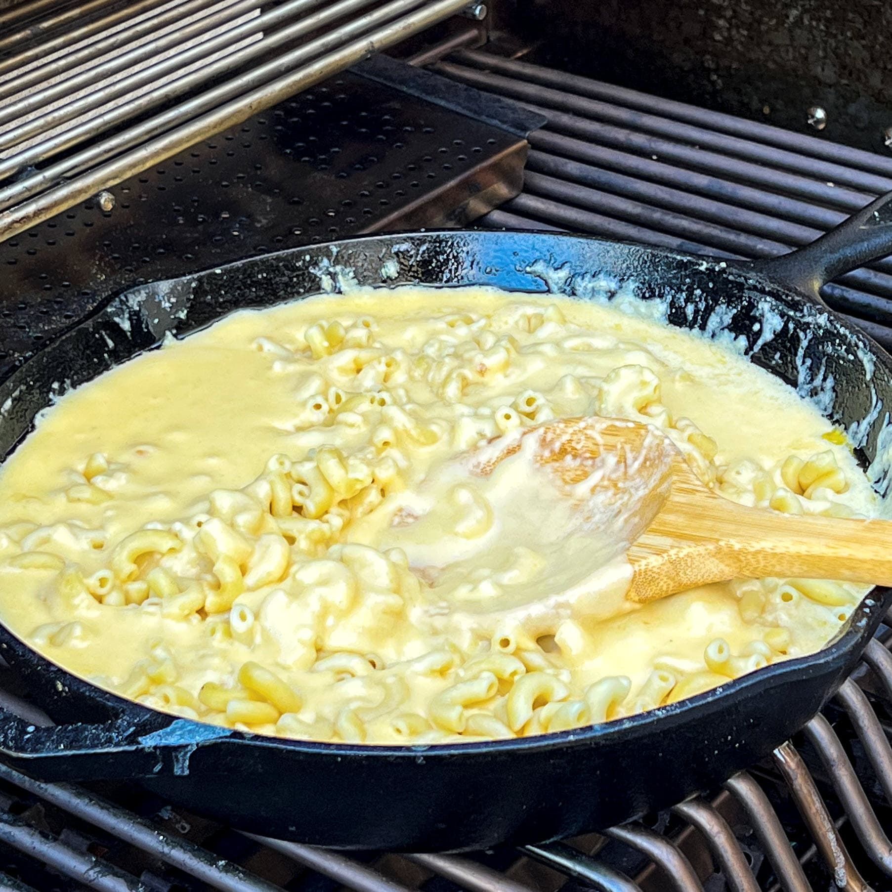Closeup of Pecan smoked salsa mac and cheese in a cast iron pan on the grill