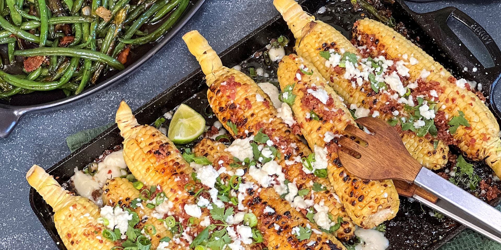 Grilled corn on the cob with toppings on the grill