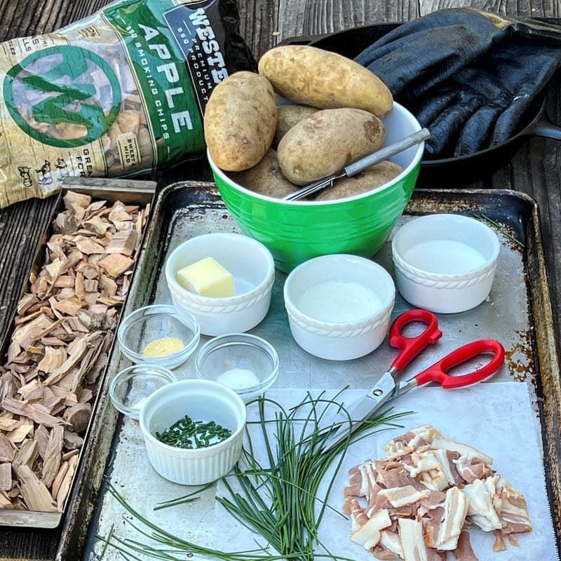 apple smoking chips in chip tray, bacon, chives, butter, salt, and a bowl of potatoes