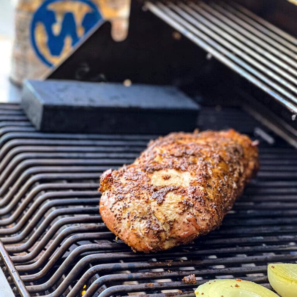 whole pork loin with onions on grill