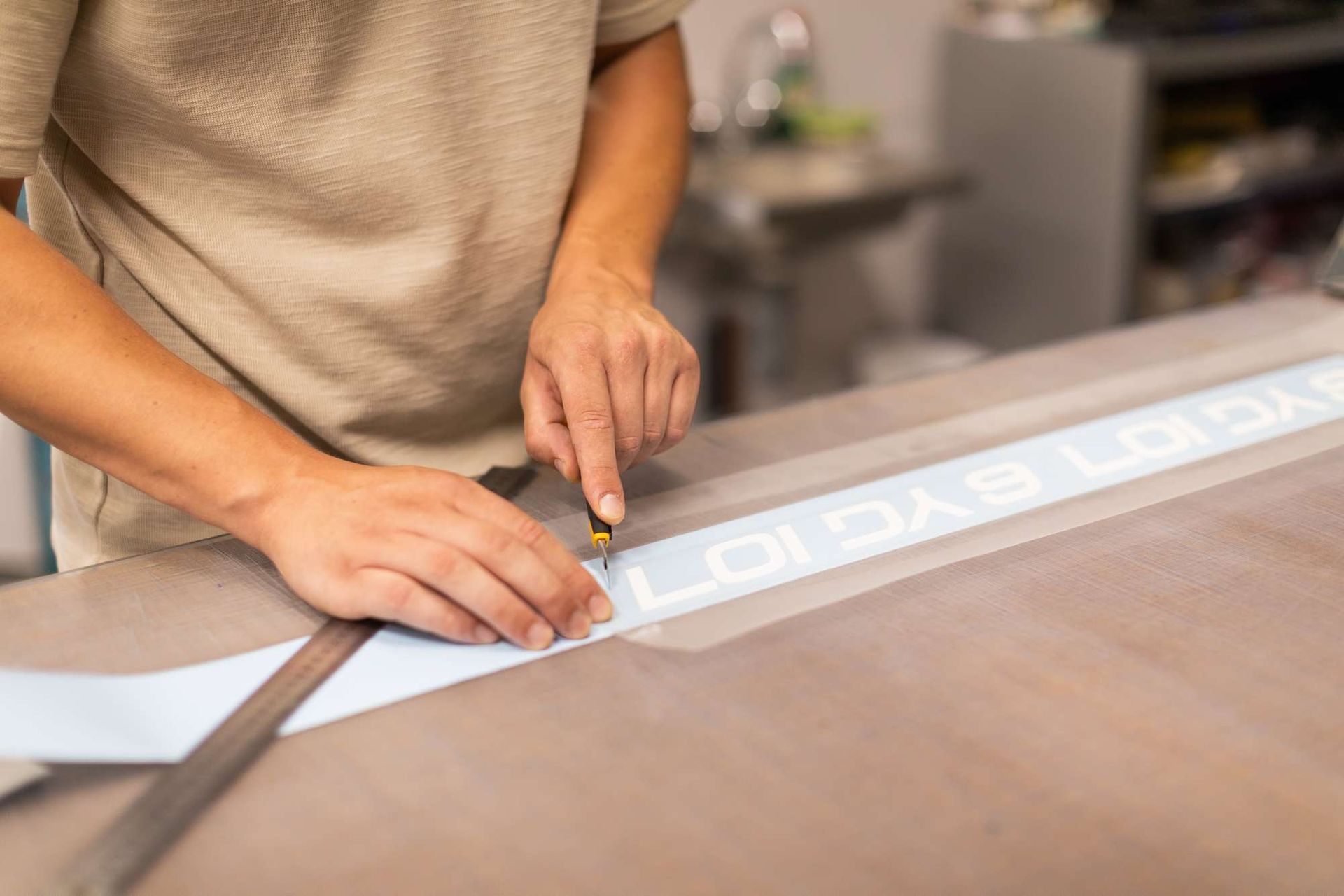 Iemand knipt een stuk papier met een liniaal.