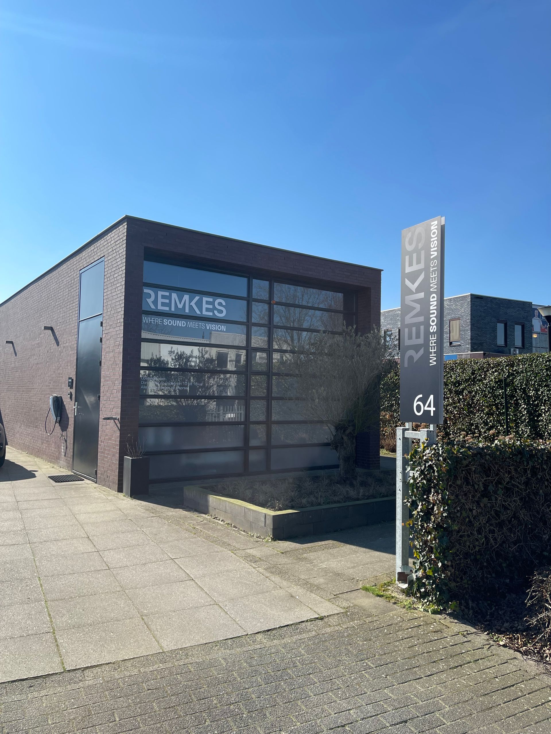 Een groot bakstenen gebouw met een bord ervoor.