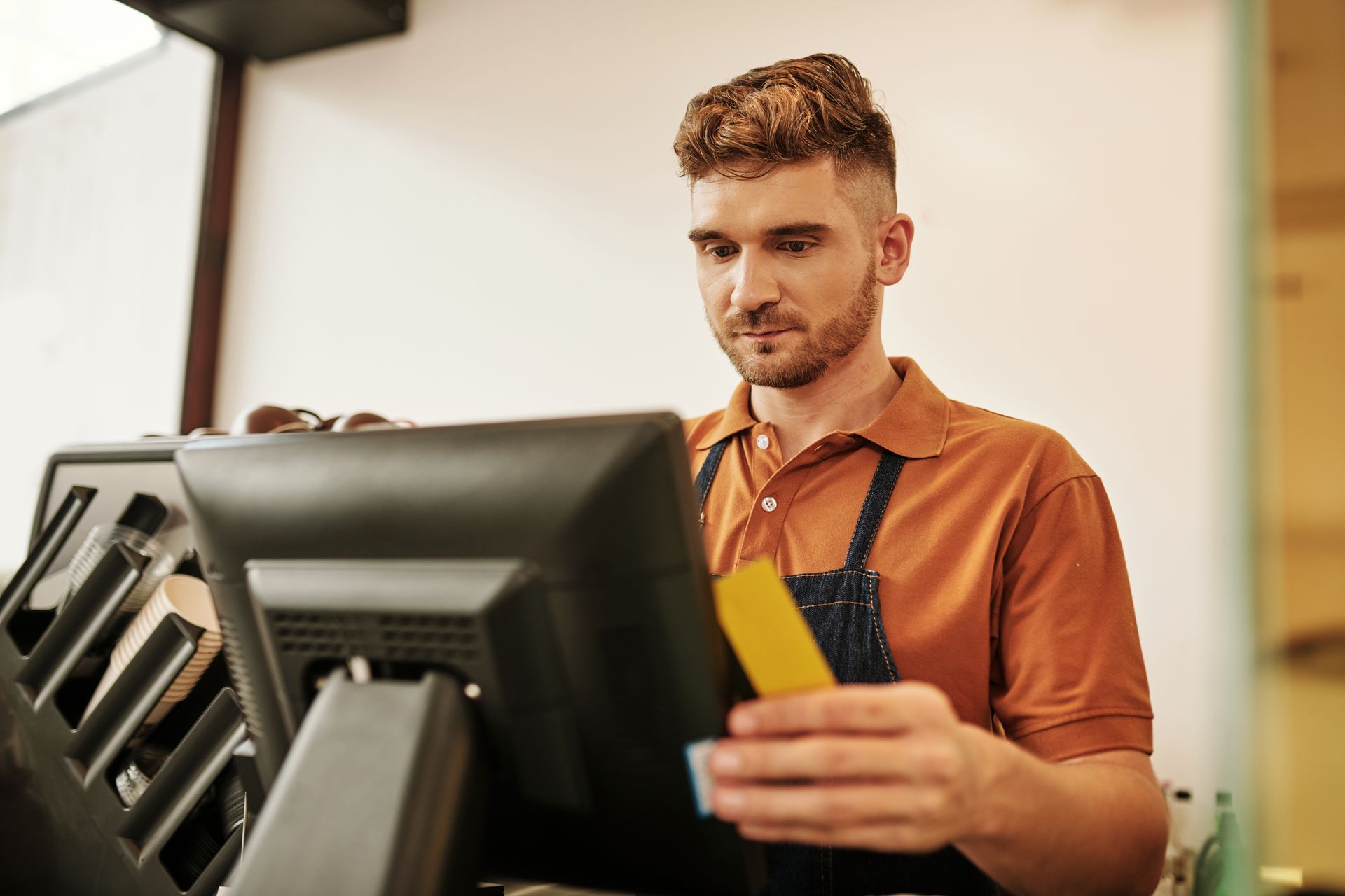 Grocery cashier scanning a yellow card at a register in a store