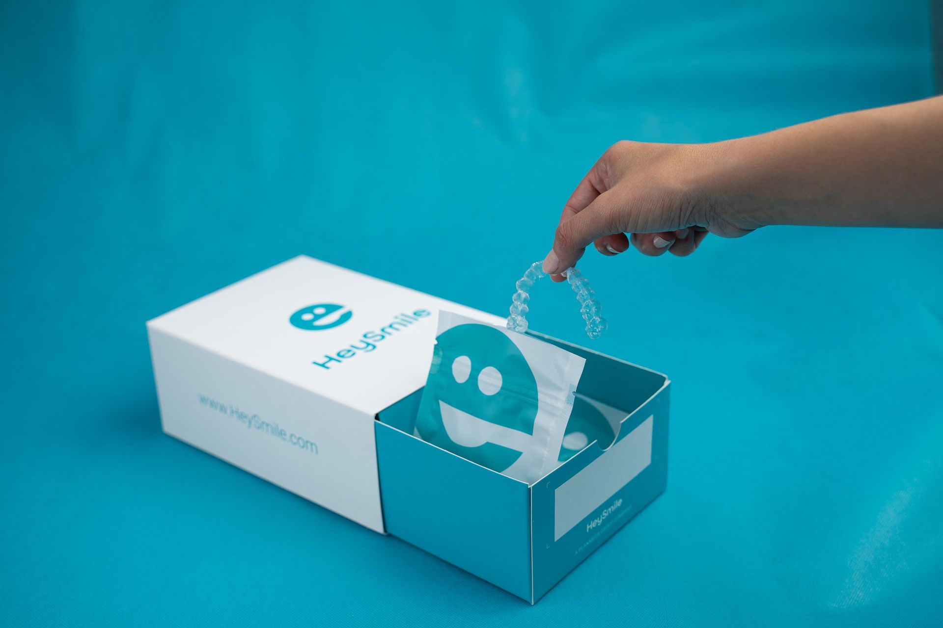 A person is opening a box with a smiley face on it.