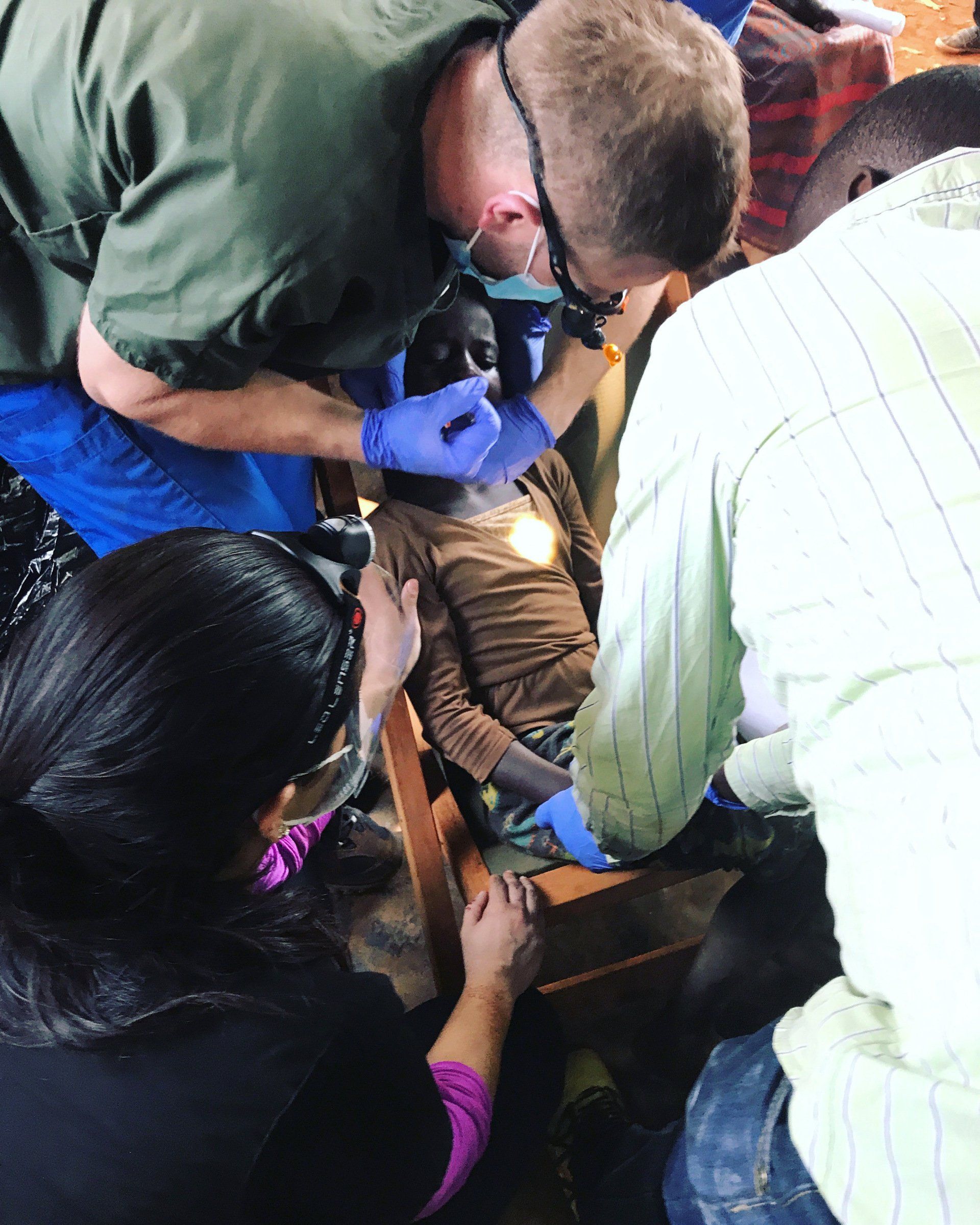 A group of people are looking at a person with a microscope