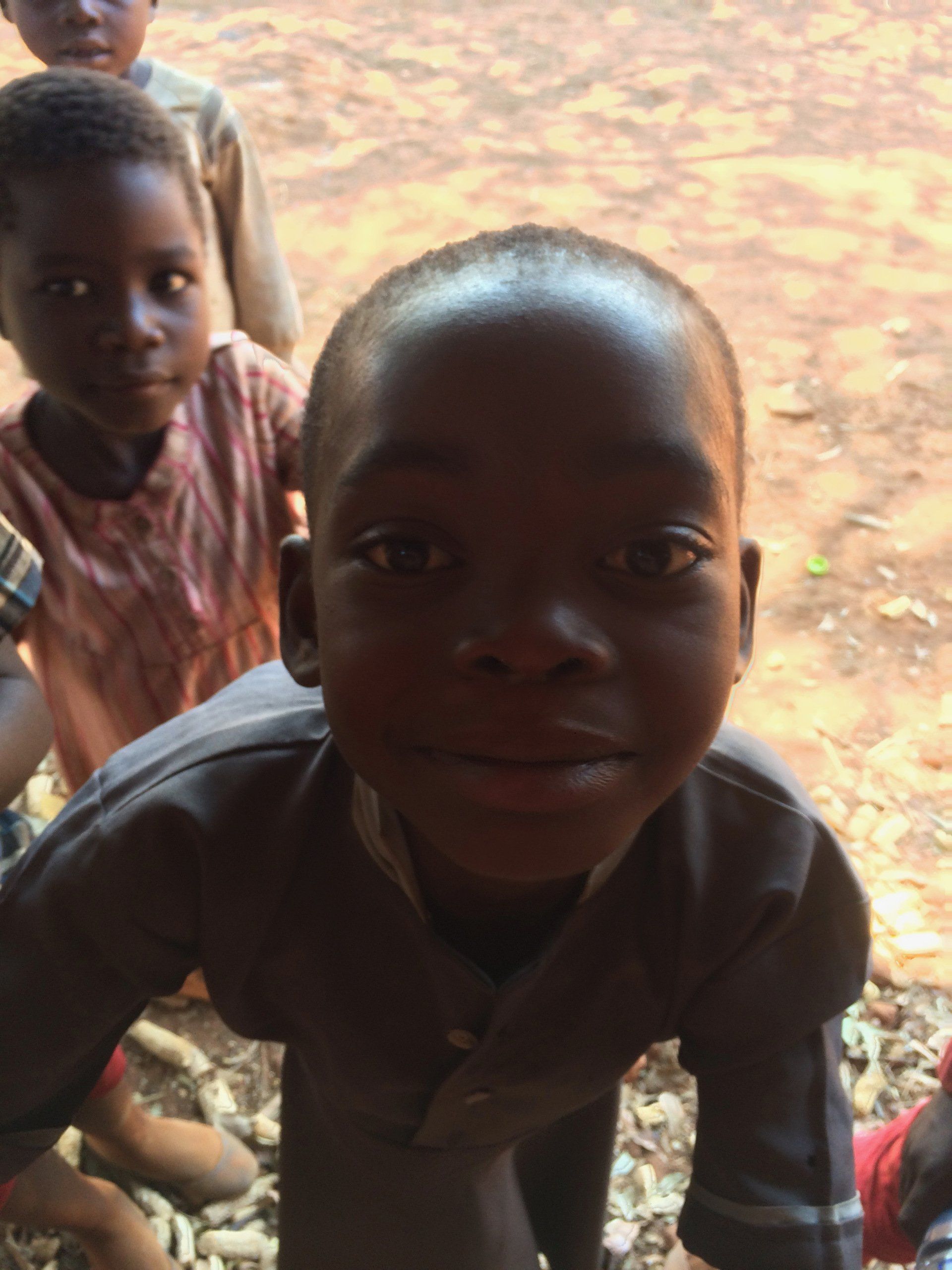 A group of children are posing for a picture and one of them is smiling