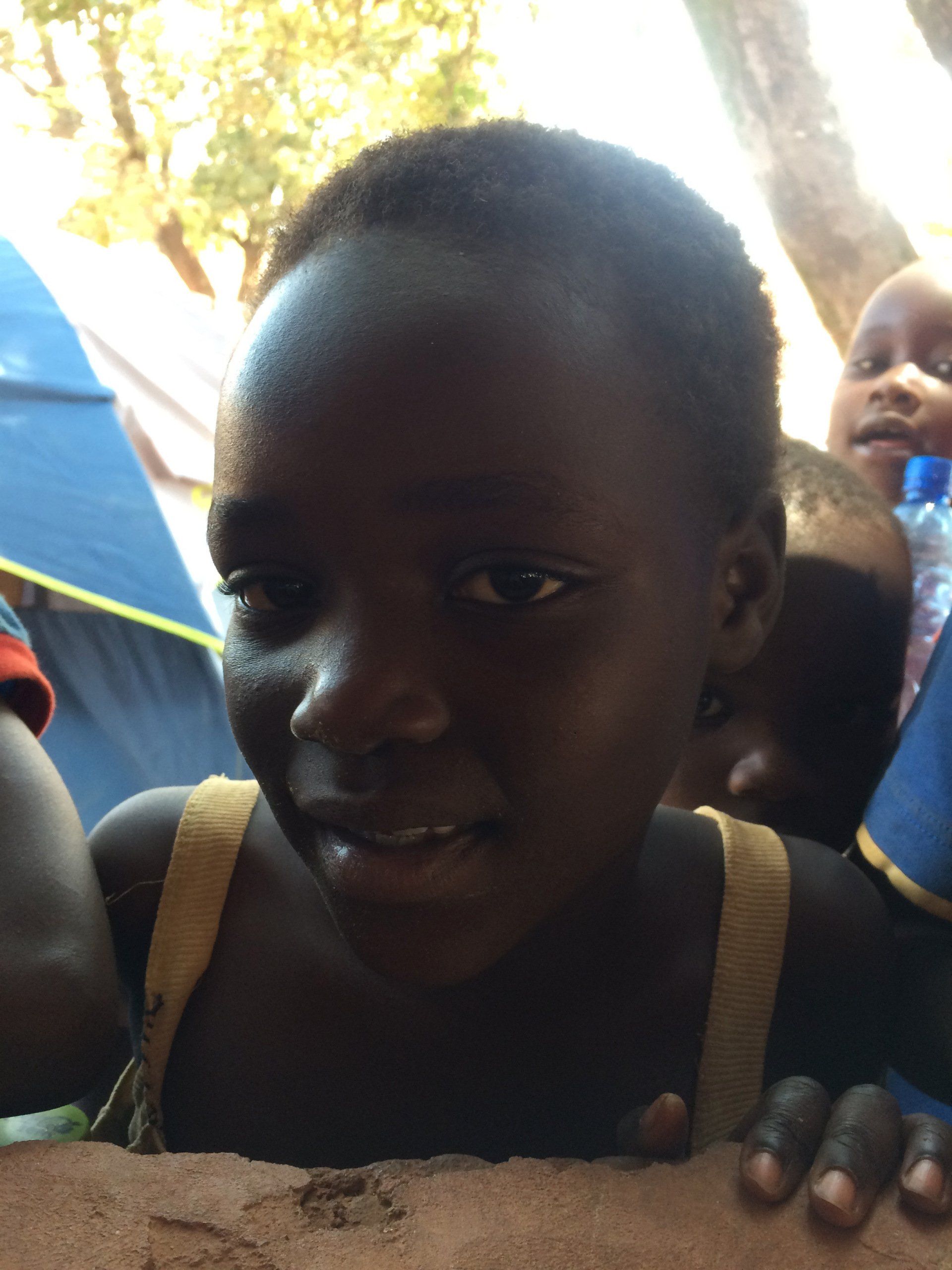 A young girl with short hair is smiling for the camera