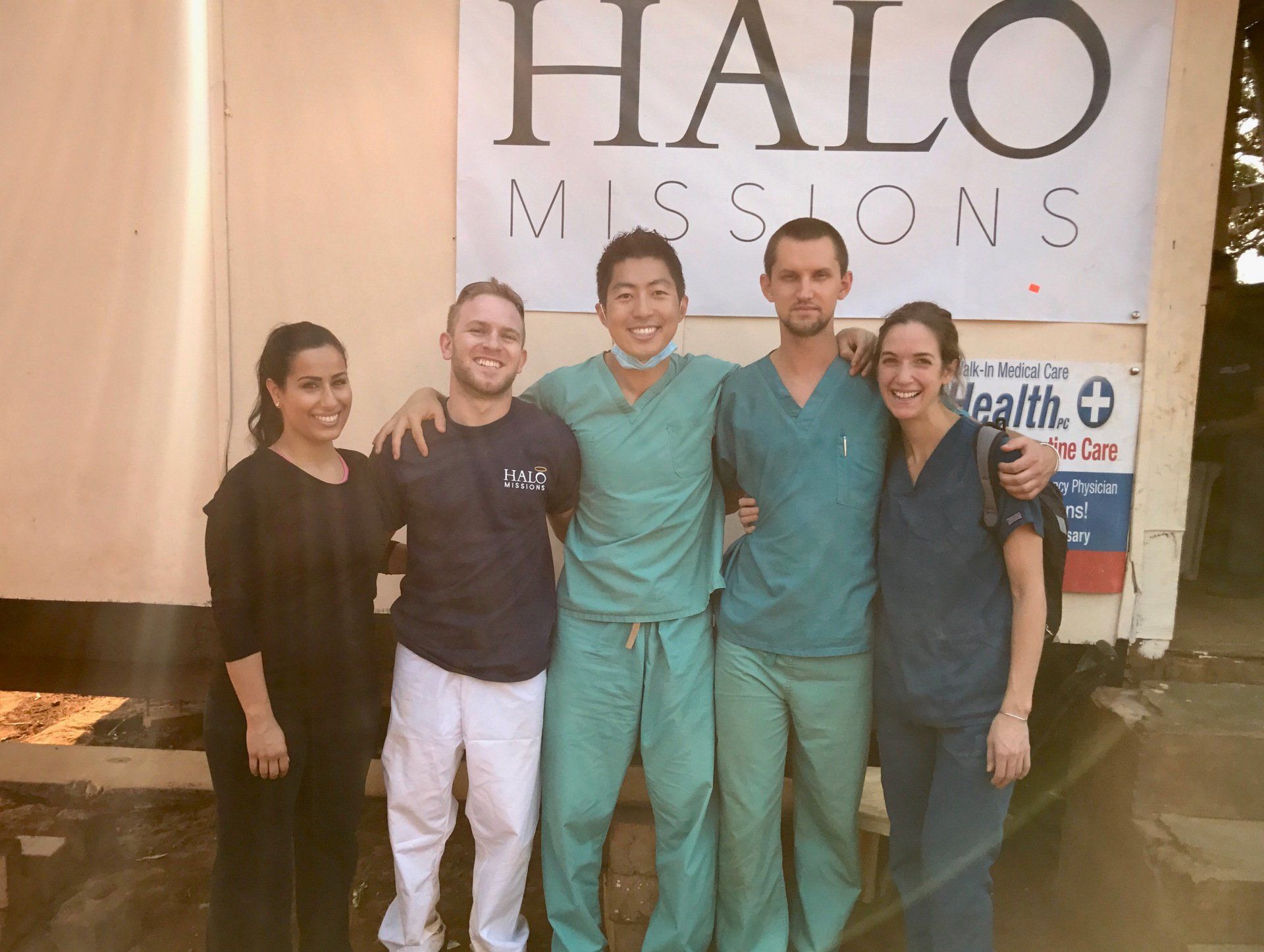 A group of people posing in front of a halo missions sign
