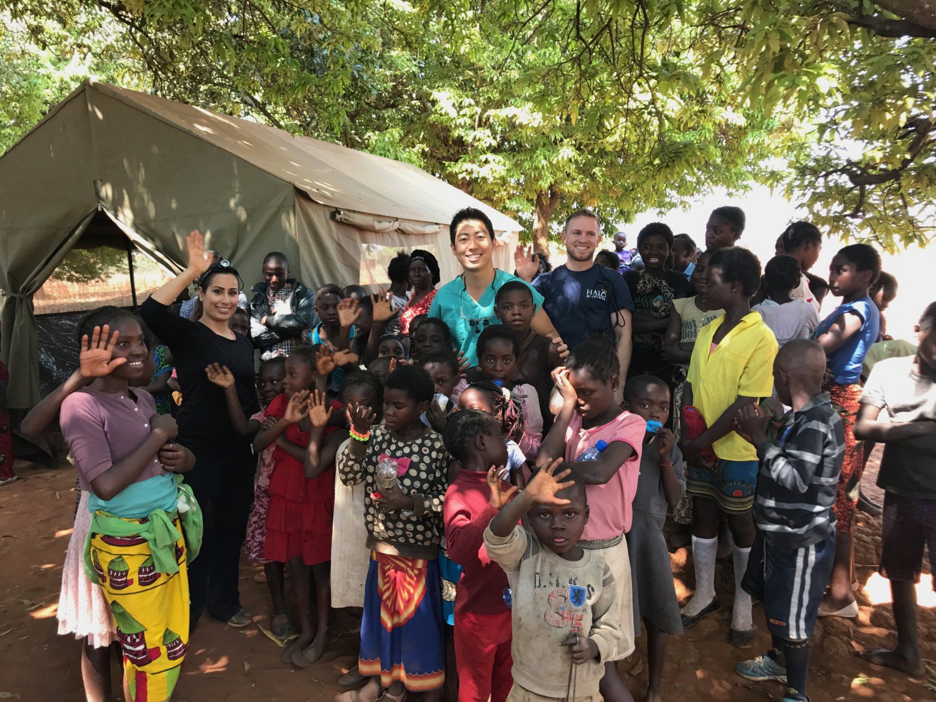 A group of people are posing for a picture in front of a tent.