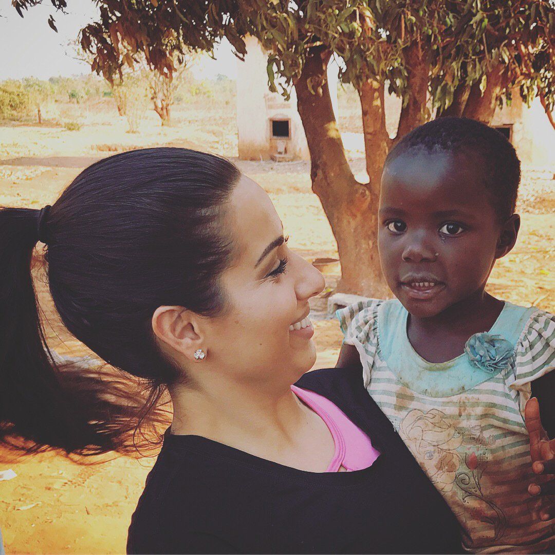 A woman is holding a little girl in her arms