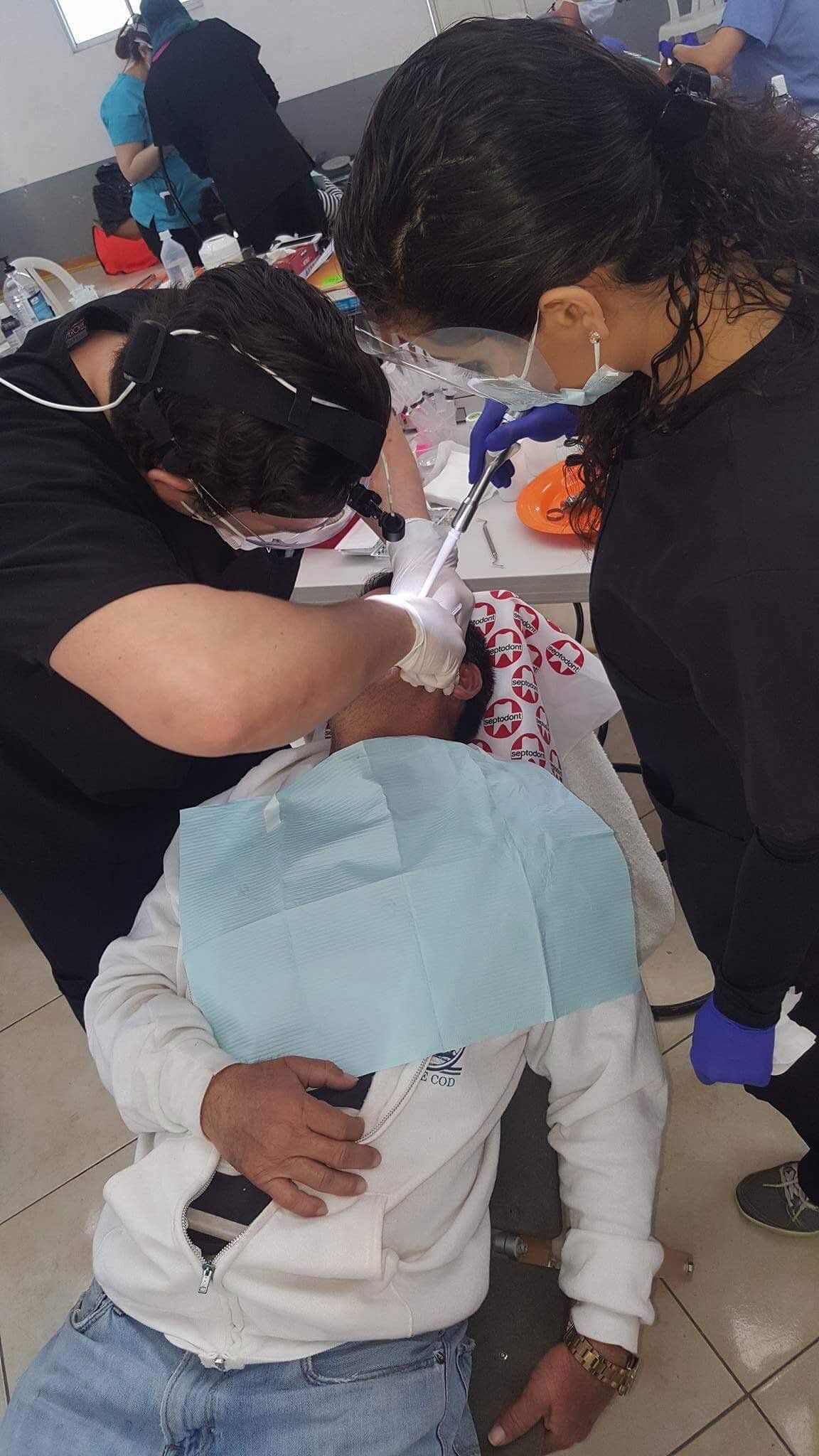 A group of people are working on a child 's teeth.