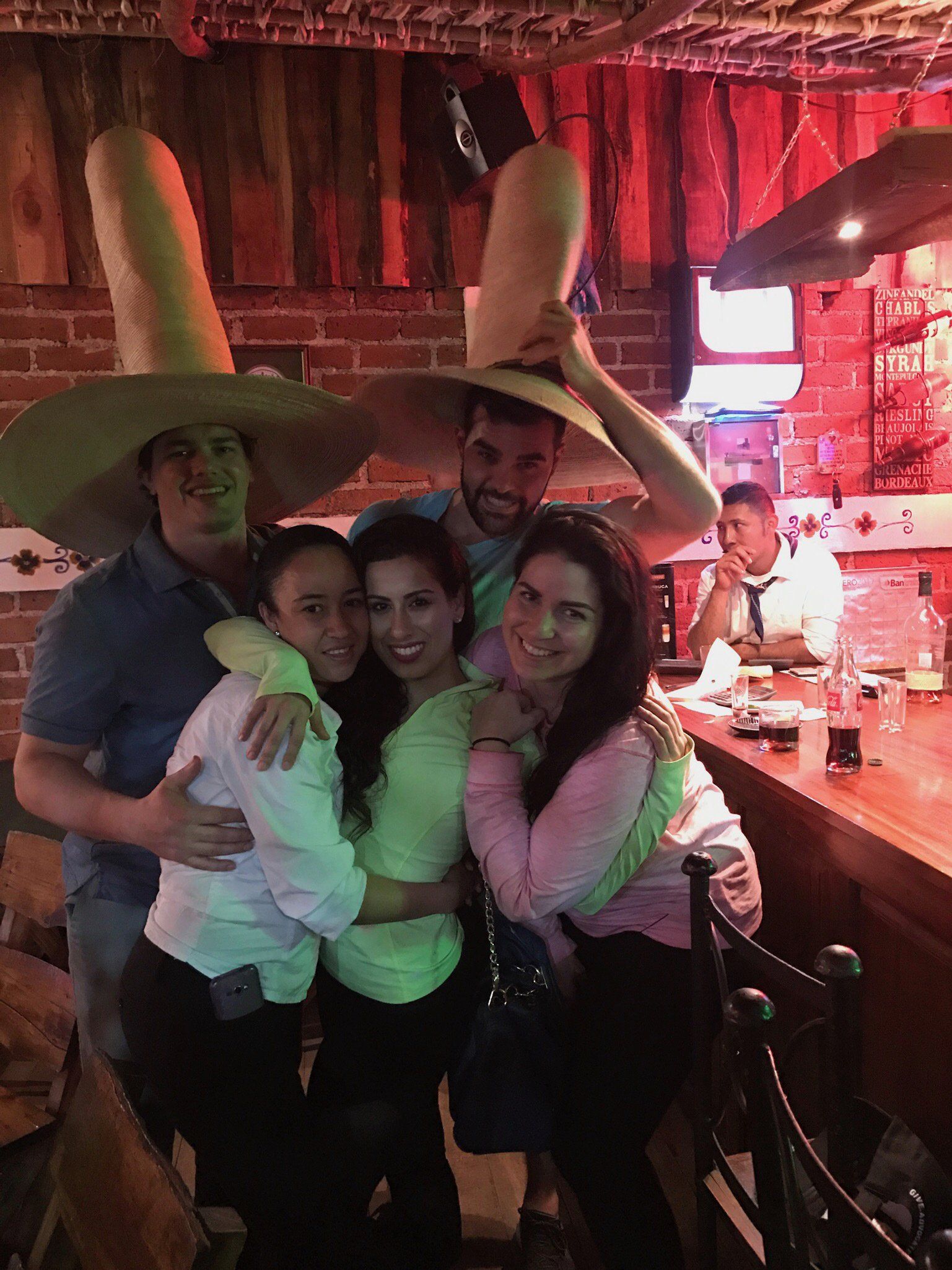 A group of people are posing for a picture in a bar.