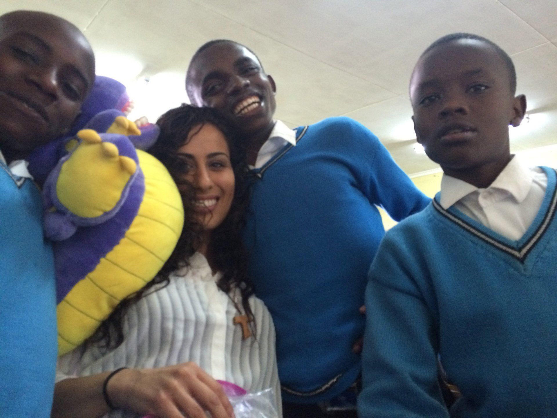 A group of people posing for a picture with a woman holding a stuffed animal