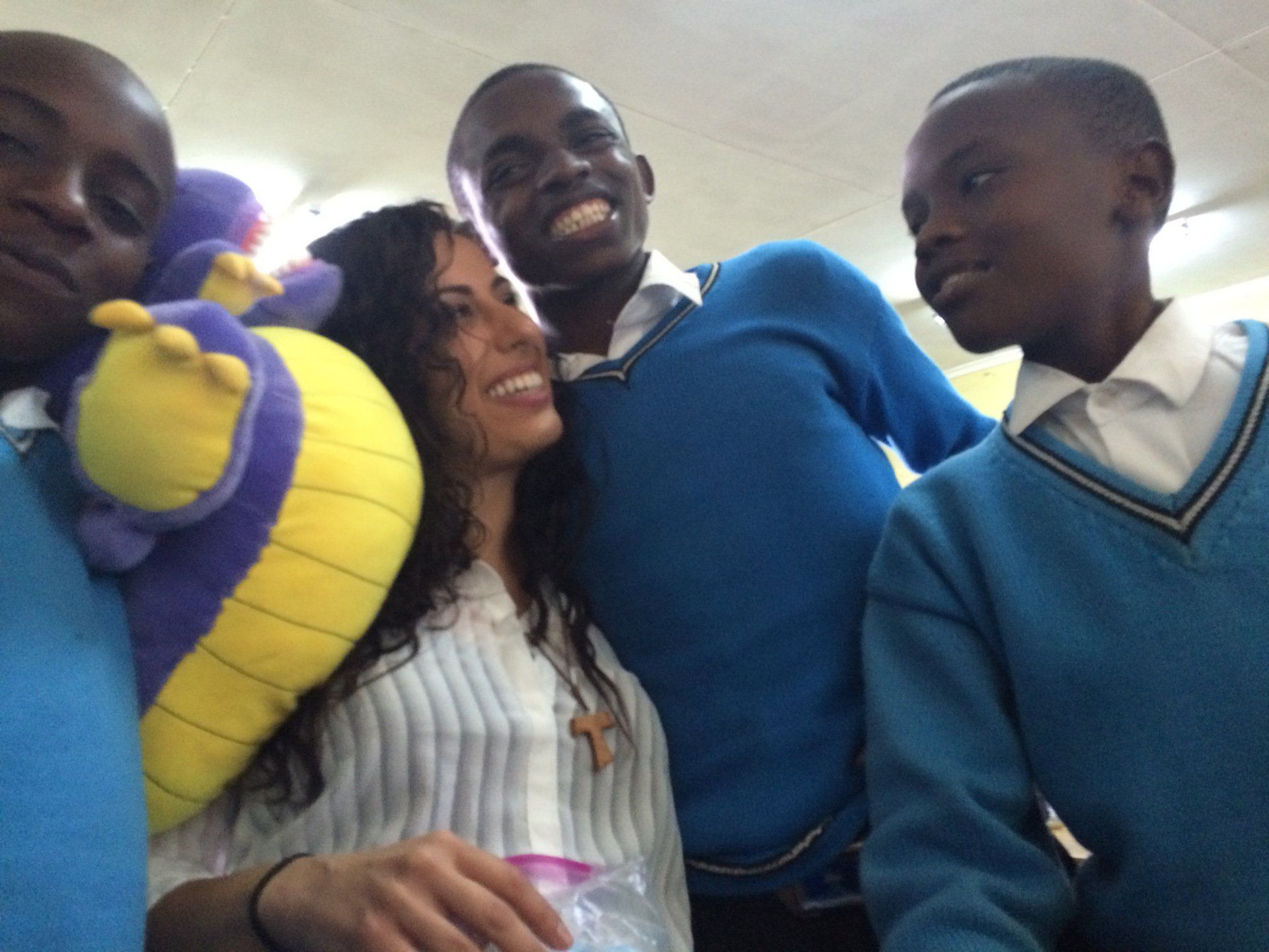A group of people are posing for a picture and one of them is holding a stuffed animal