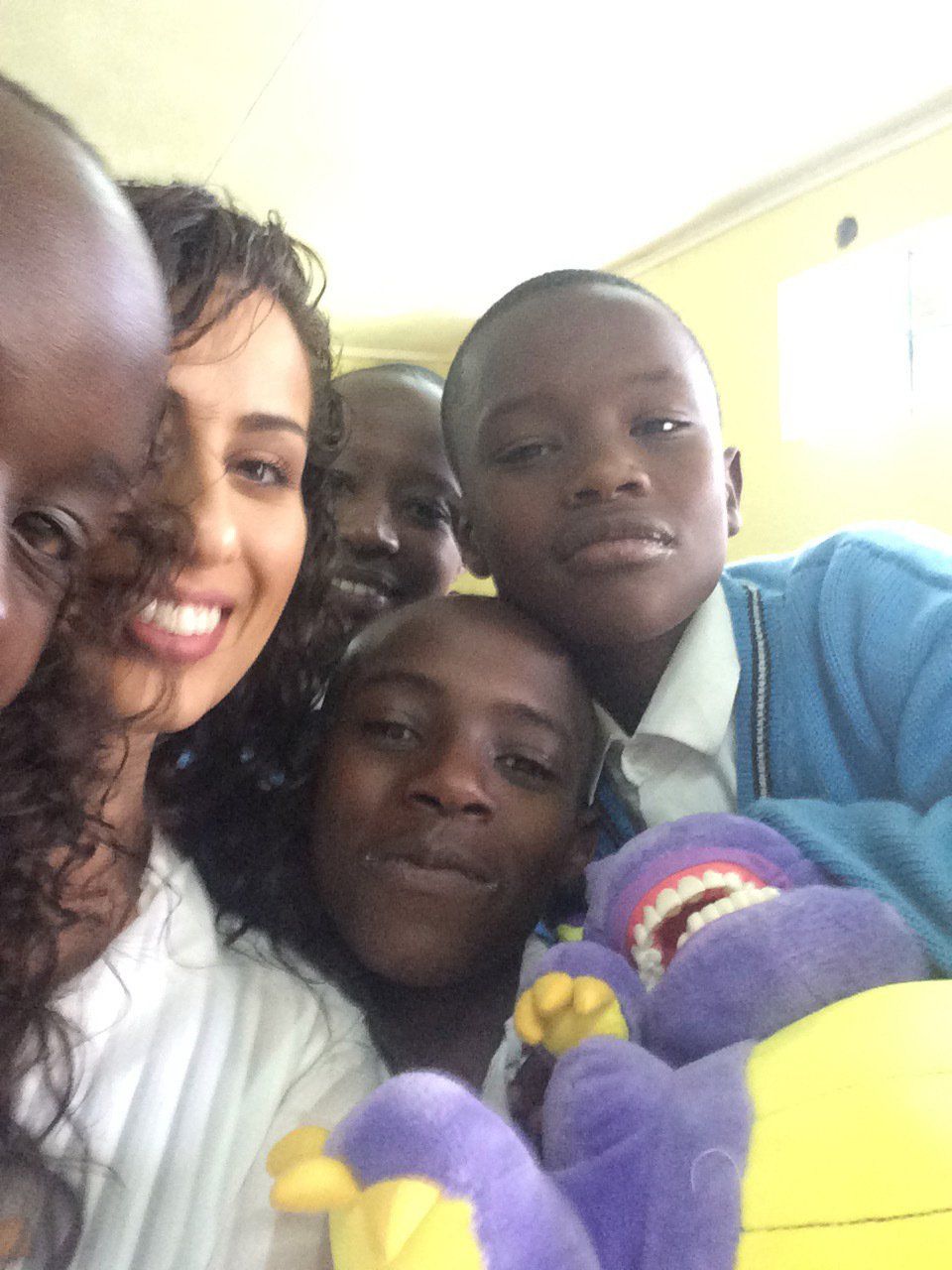 A group of people posing for a picture with purple stuffed animals