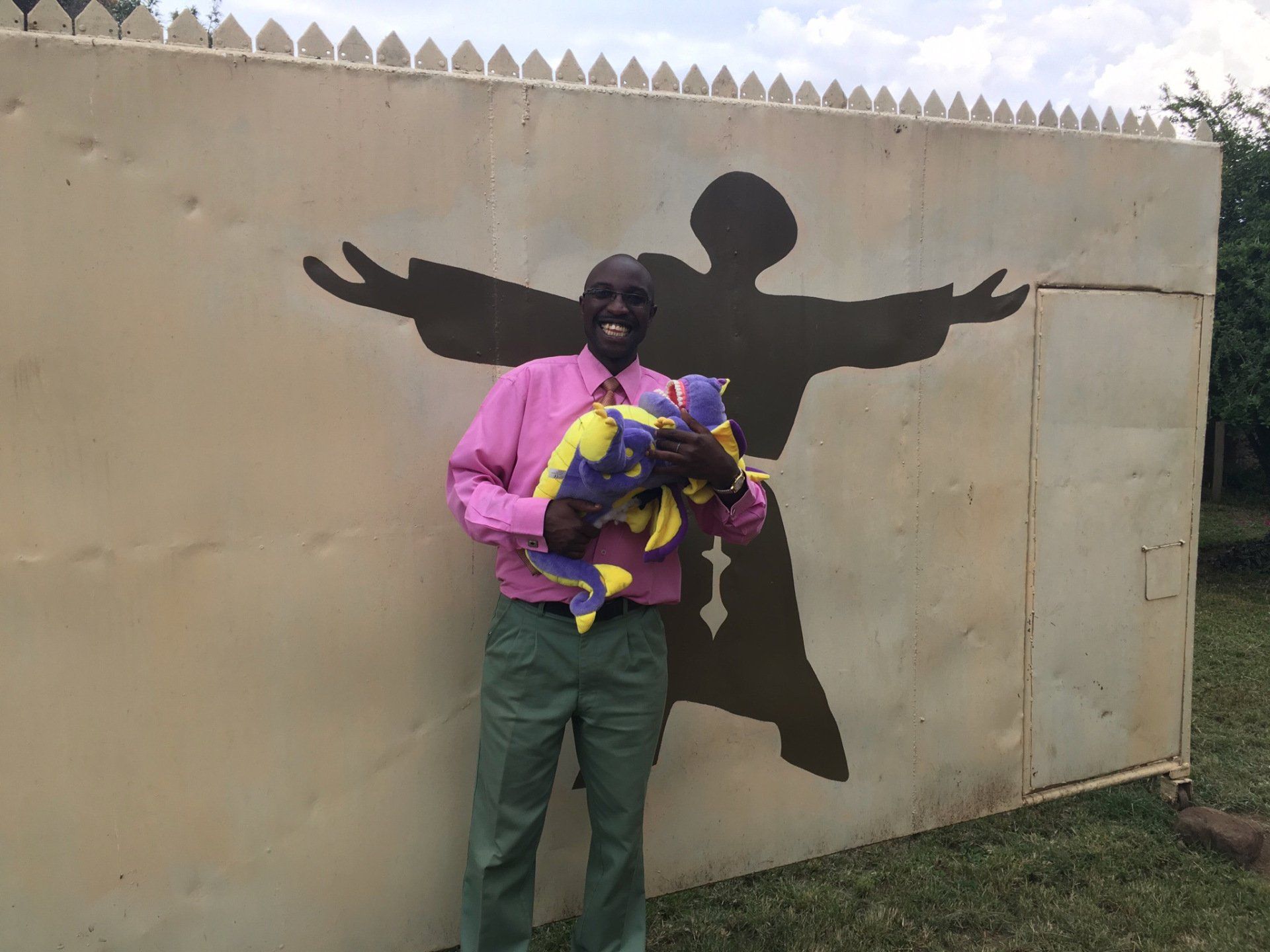 A man standing in front of a wall with a shadow of jesus on it