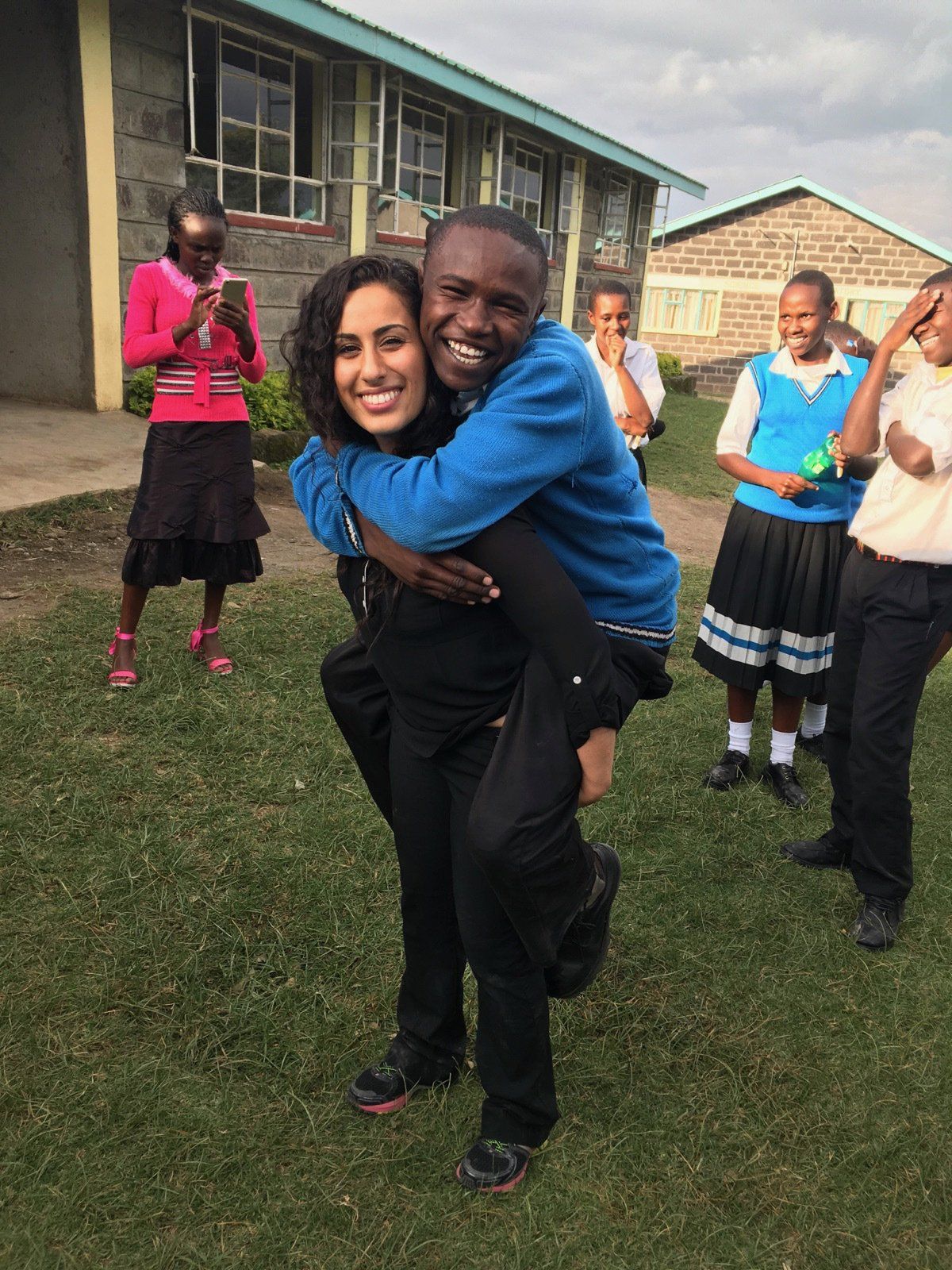 A man is carrying a woman on his back in a field