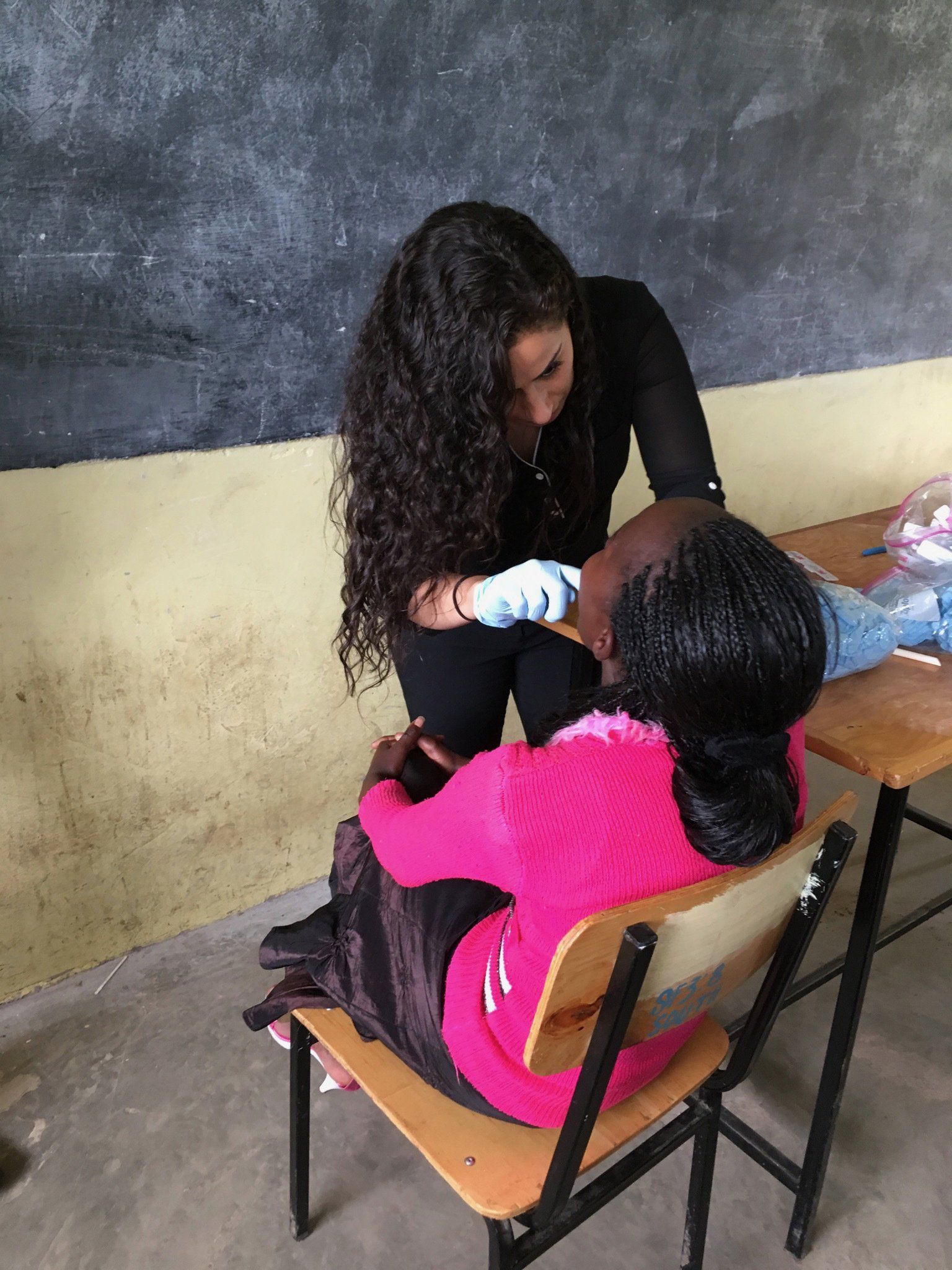 A woman is sitting at a desk with a child.