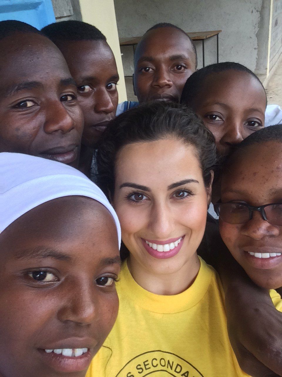 A group of people are posing for a picture and one of them is wearing a yellow shirt that says seconda