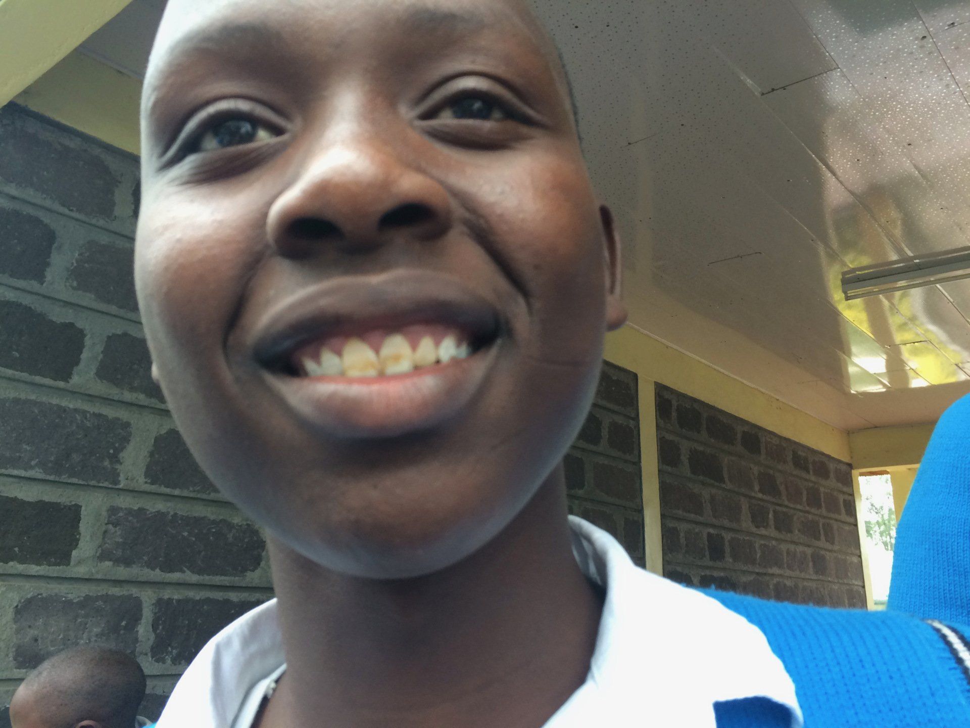 A close up of a person 's face with a brick wall in the background
