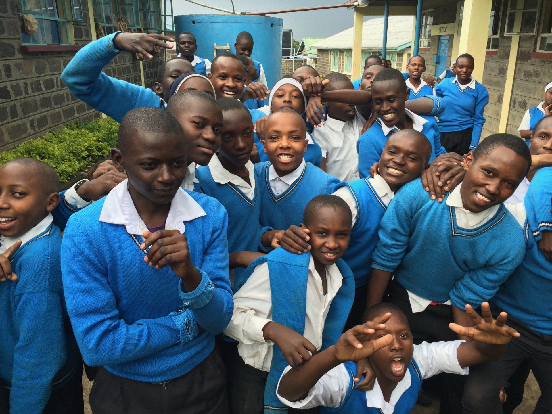 A group of children in blue uniforms are posing for a picture
