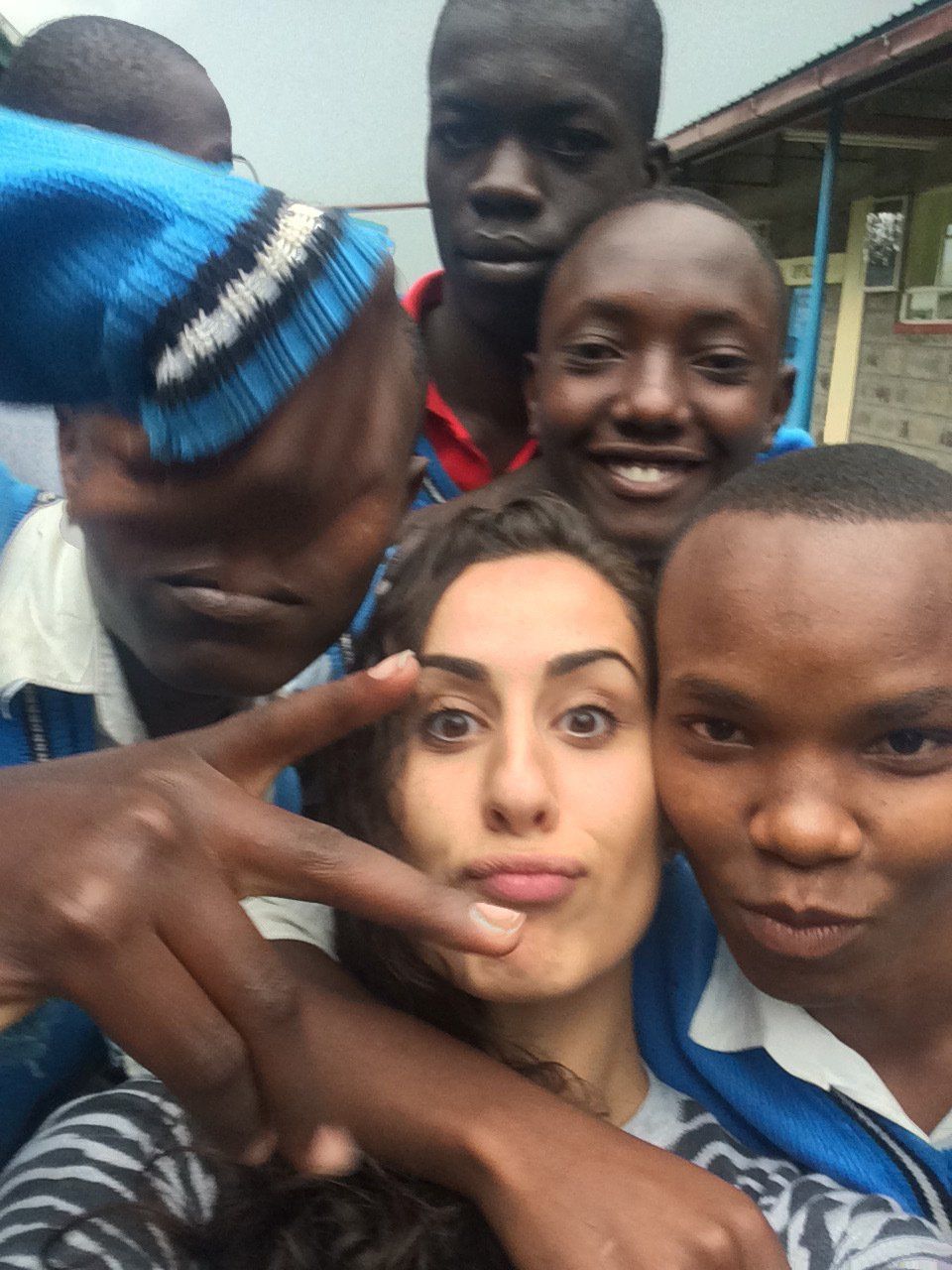 A group of people are posing for a picture and one of them is wearing a blue hat