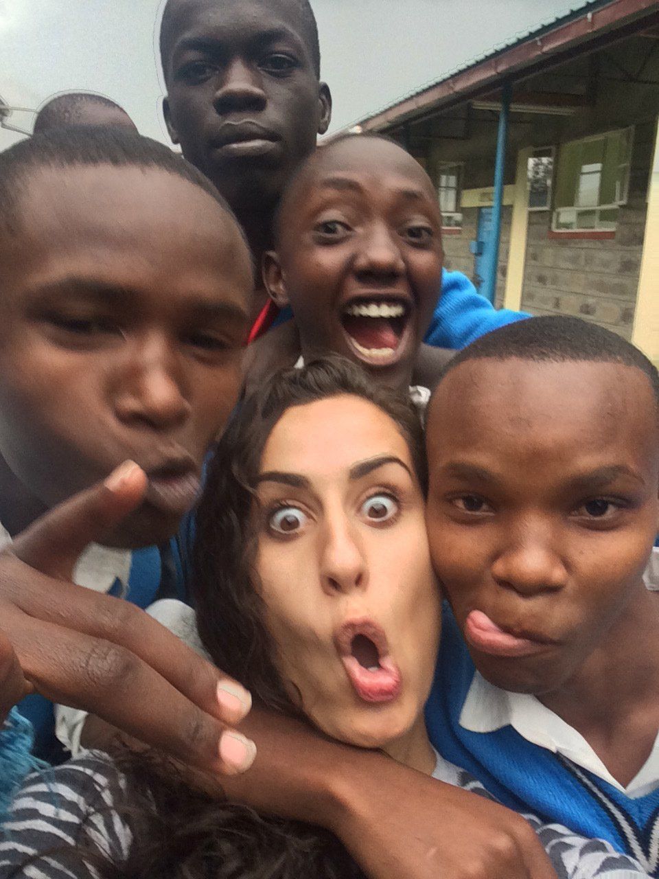 A group of people are posing for a picture and one of them is making a funny face