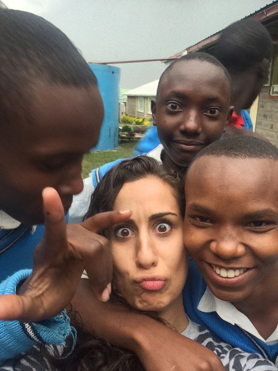 A group of people are posing for a picture and one of them is making a funny face