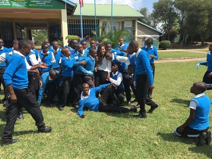 A group of children in blue uniforms are posing for a picture