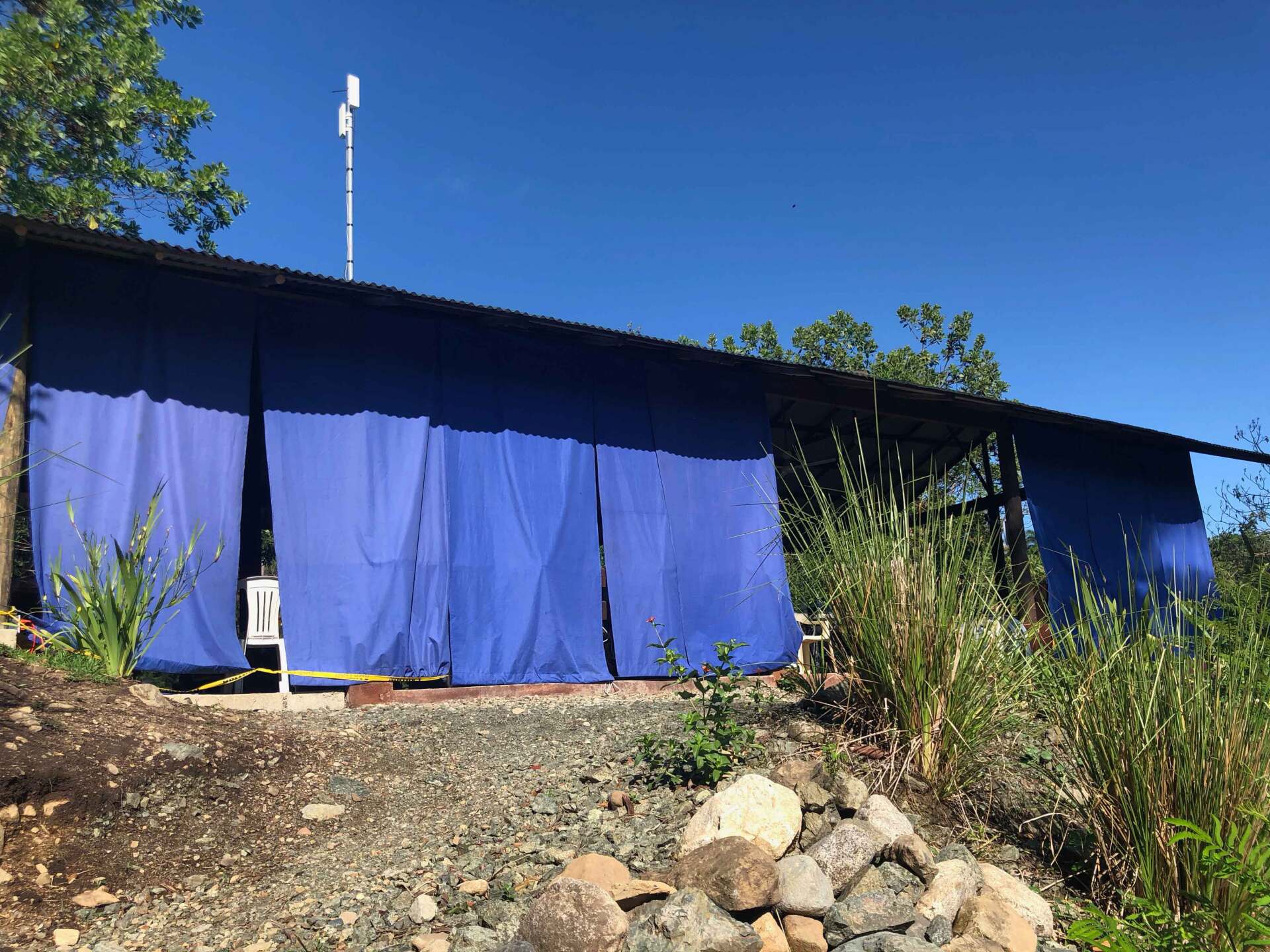 A blue tent is sitting on top of a dirt hill.