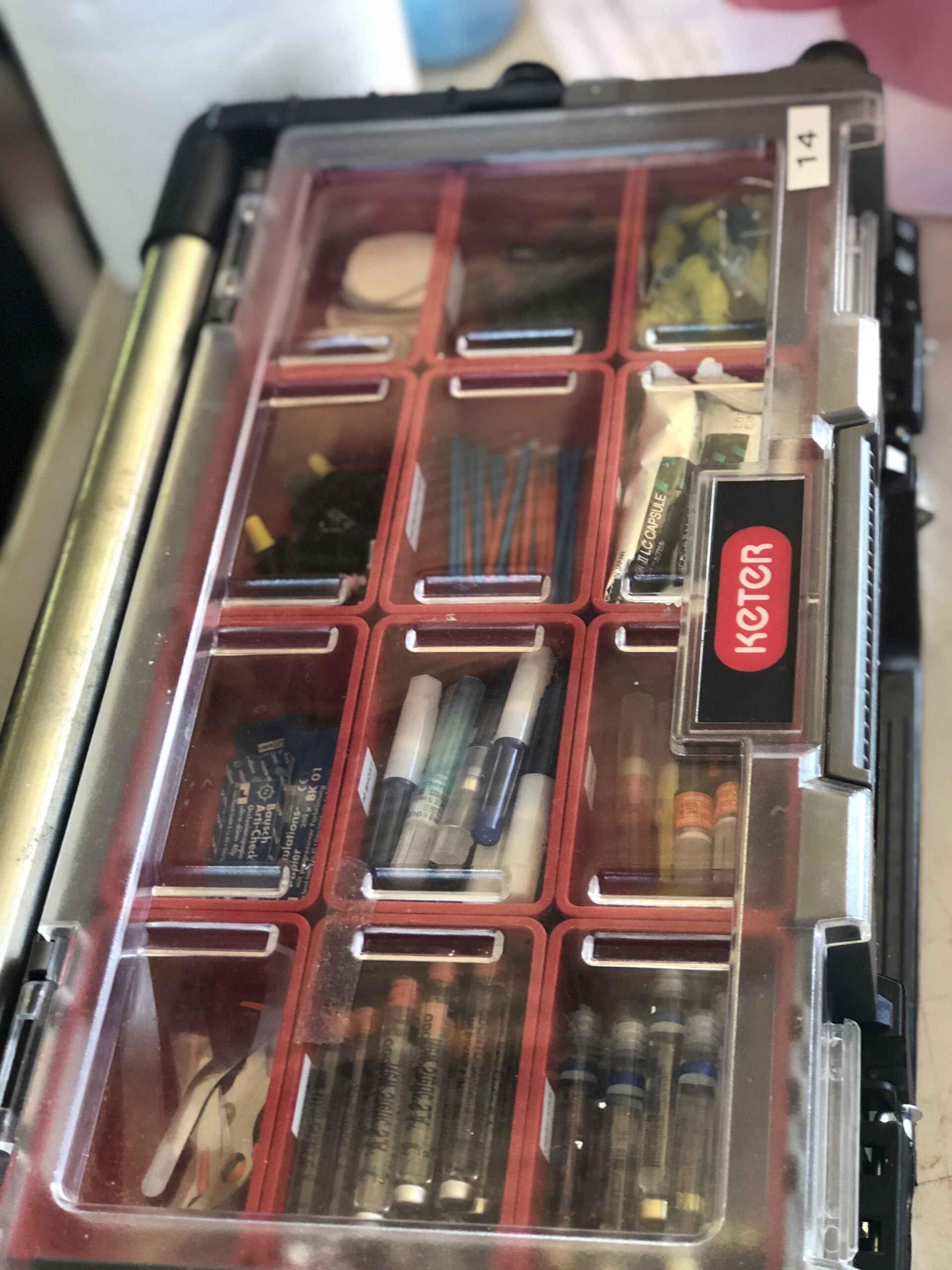 A clear plastic container with red dividers and a label that says hotter