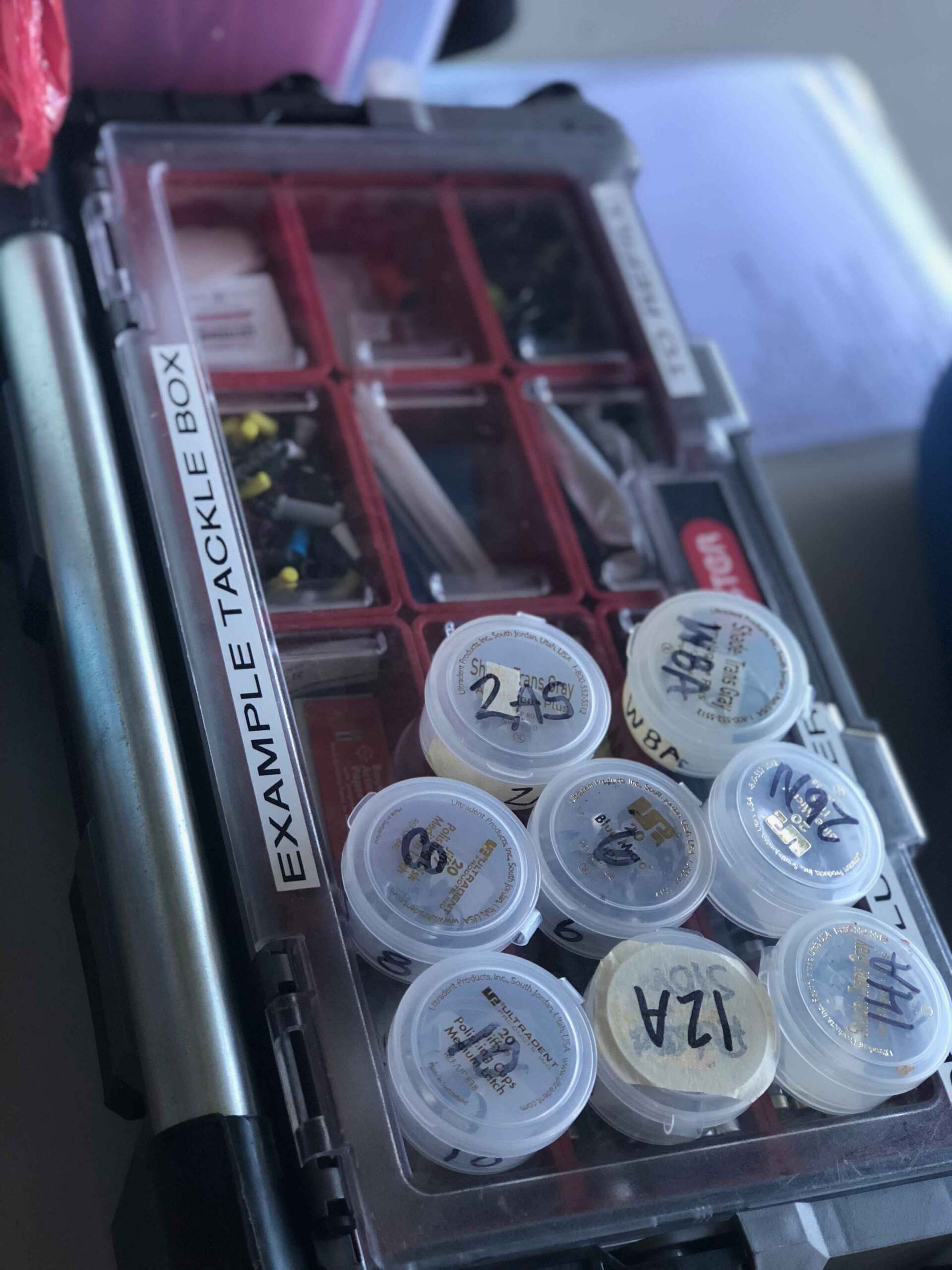 A fishing tackle box filled with small plastic containers