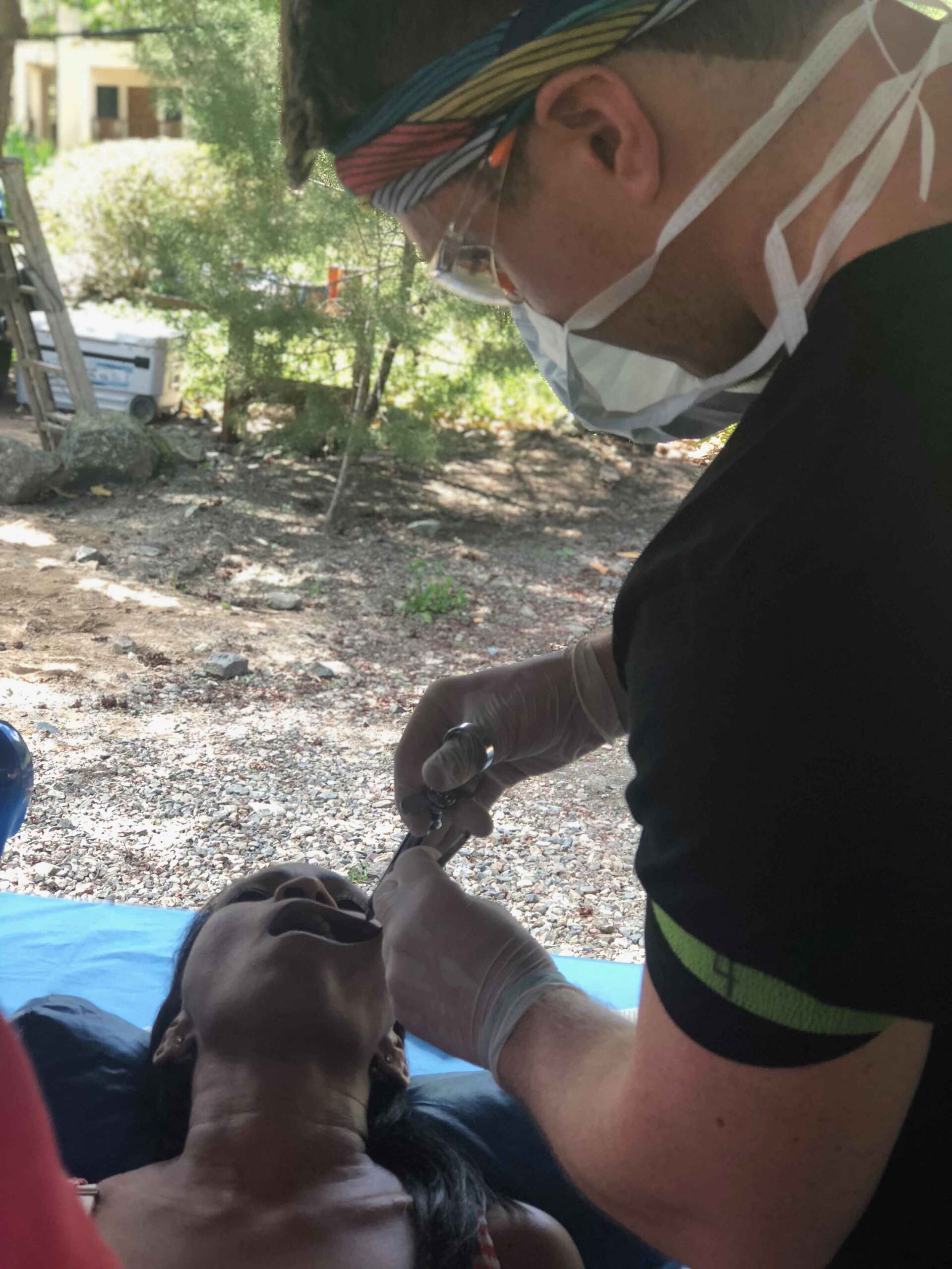 A man wearing a mask is examining a woman 's face