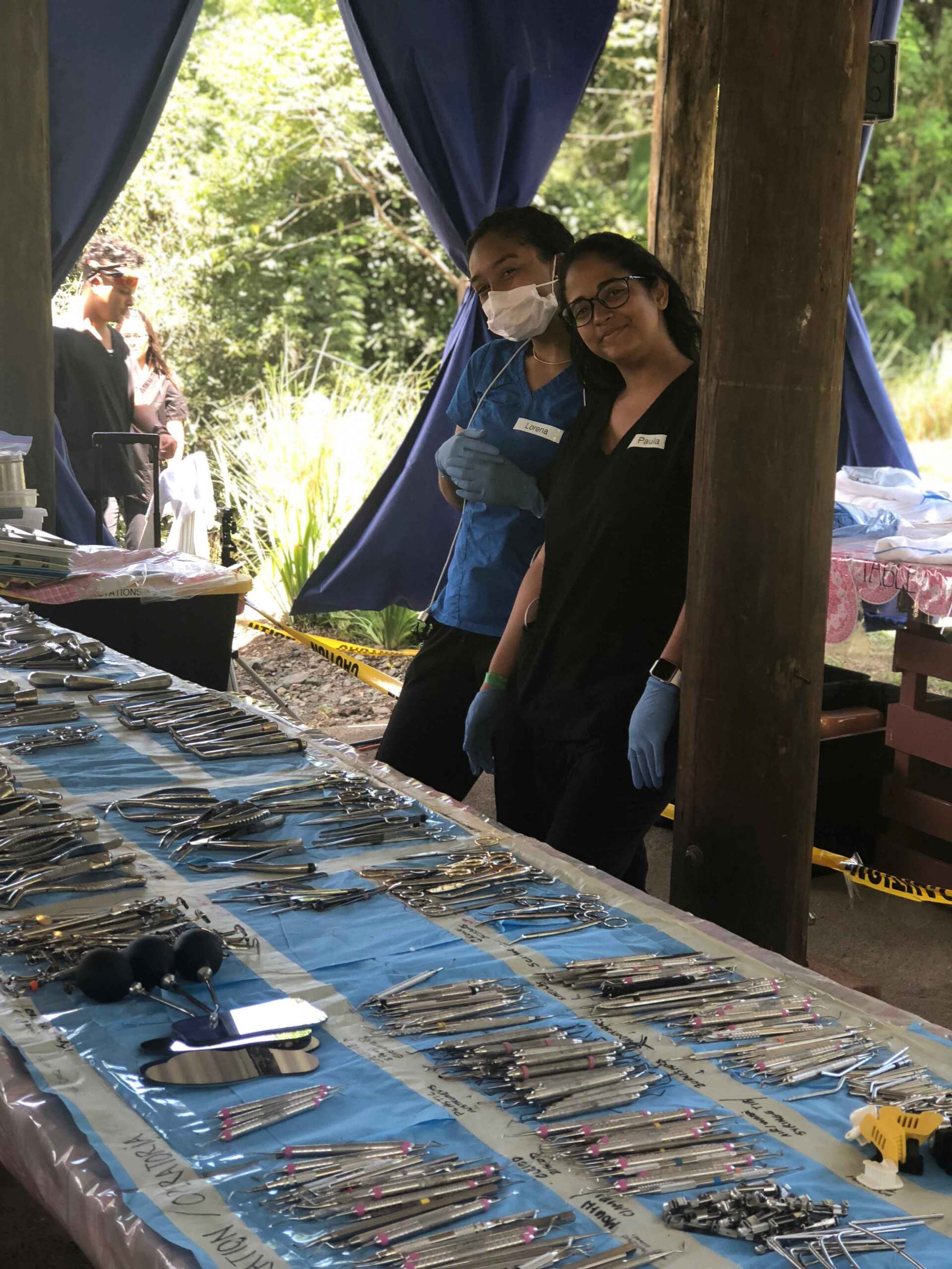 Two women are standing next to a table with a lot of jewelry on it.